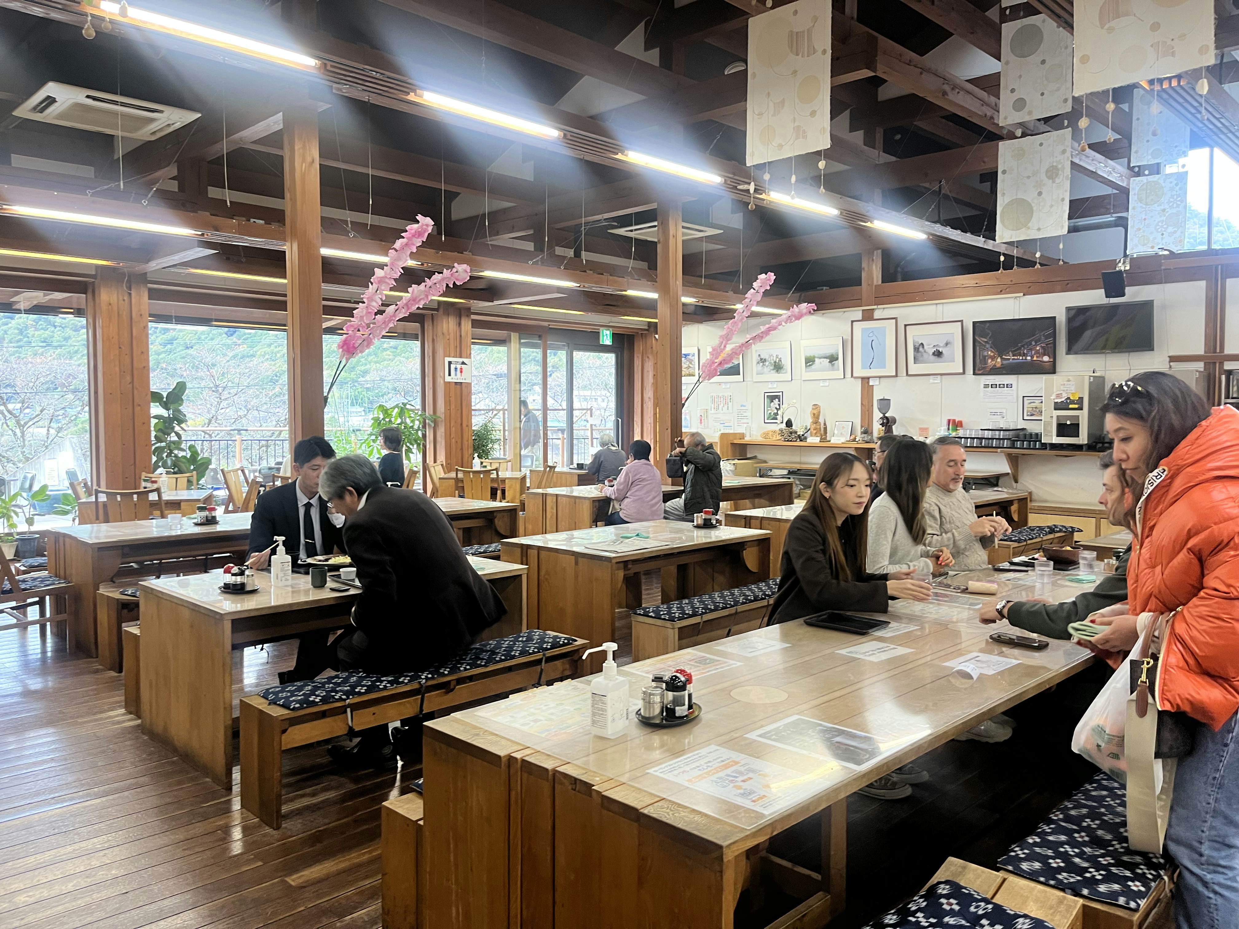 People inside a bright restaurant with modern tables and benches.