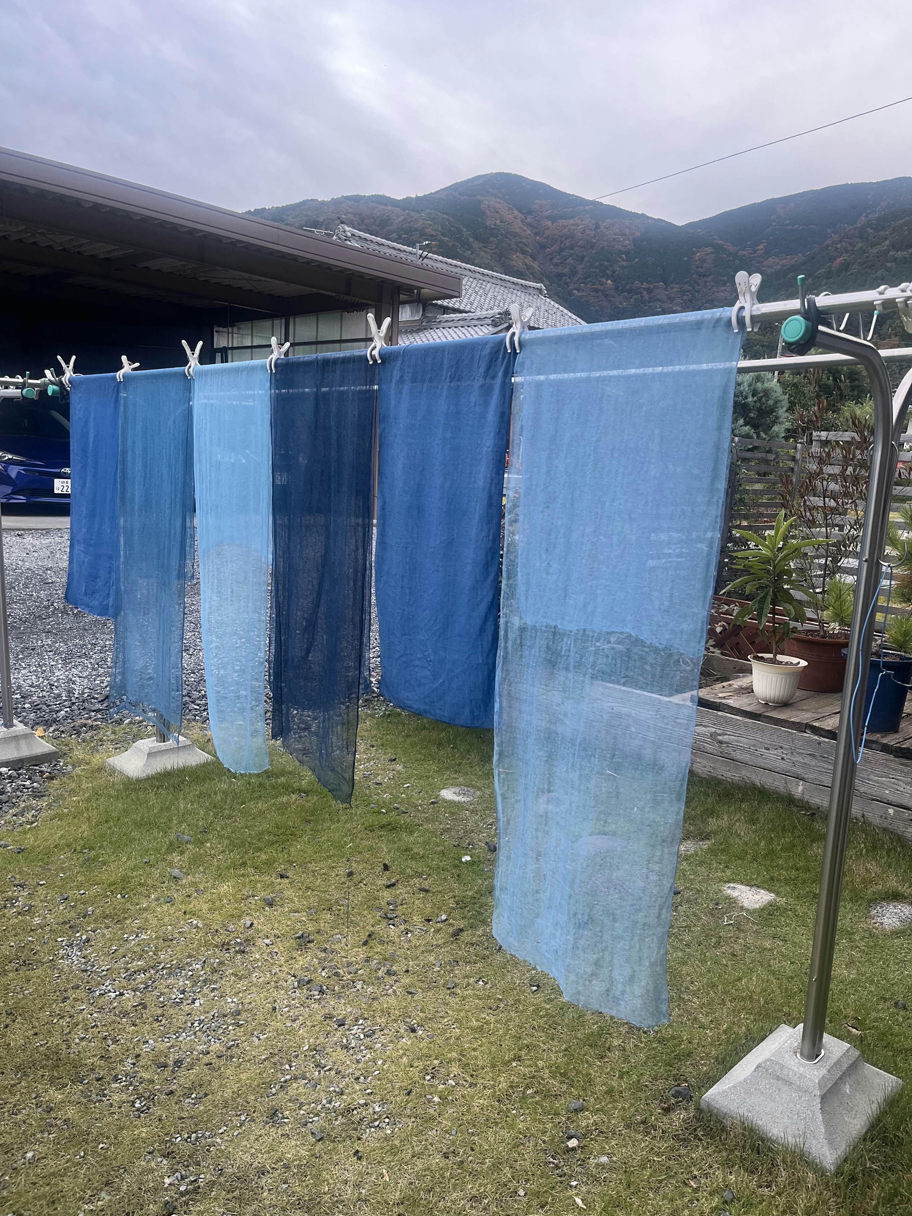 Pieces of fabric dyed blue hanging on a clothesline.