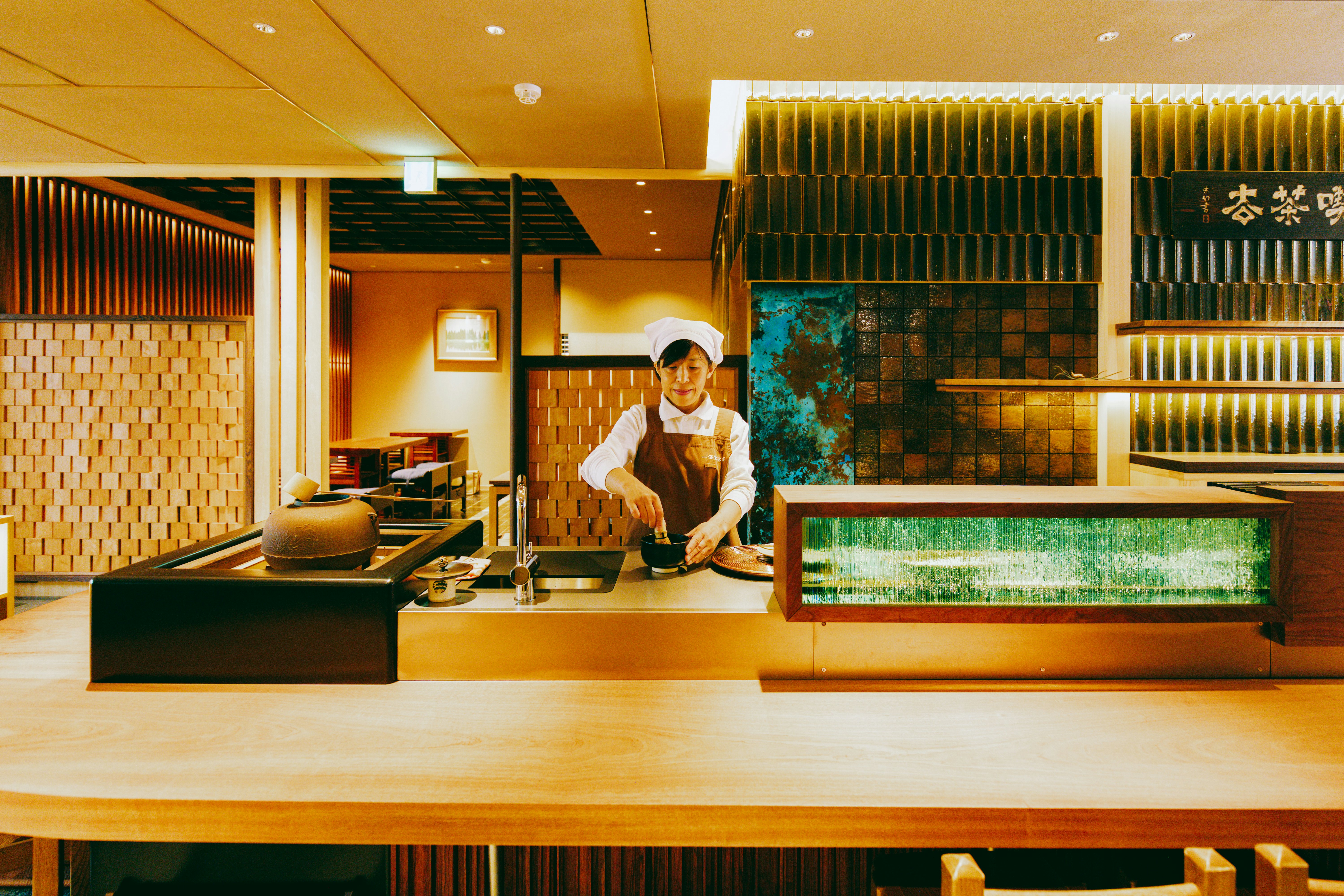 A woman makes matcha in a traditional teahouse.