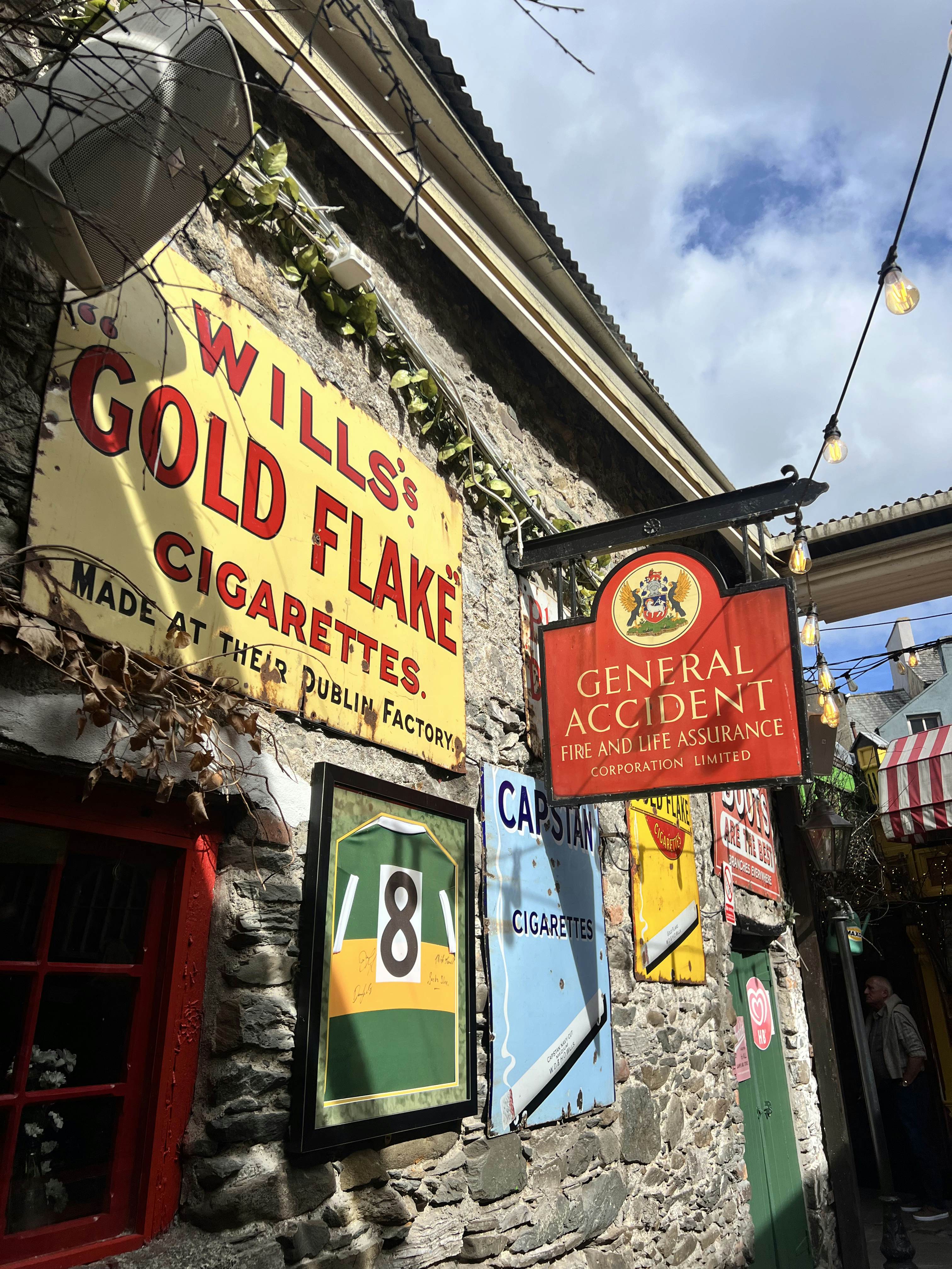 A wall covered in vintage signs and adverts.