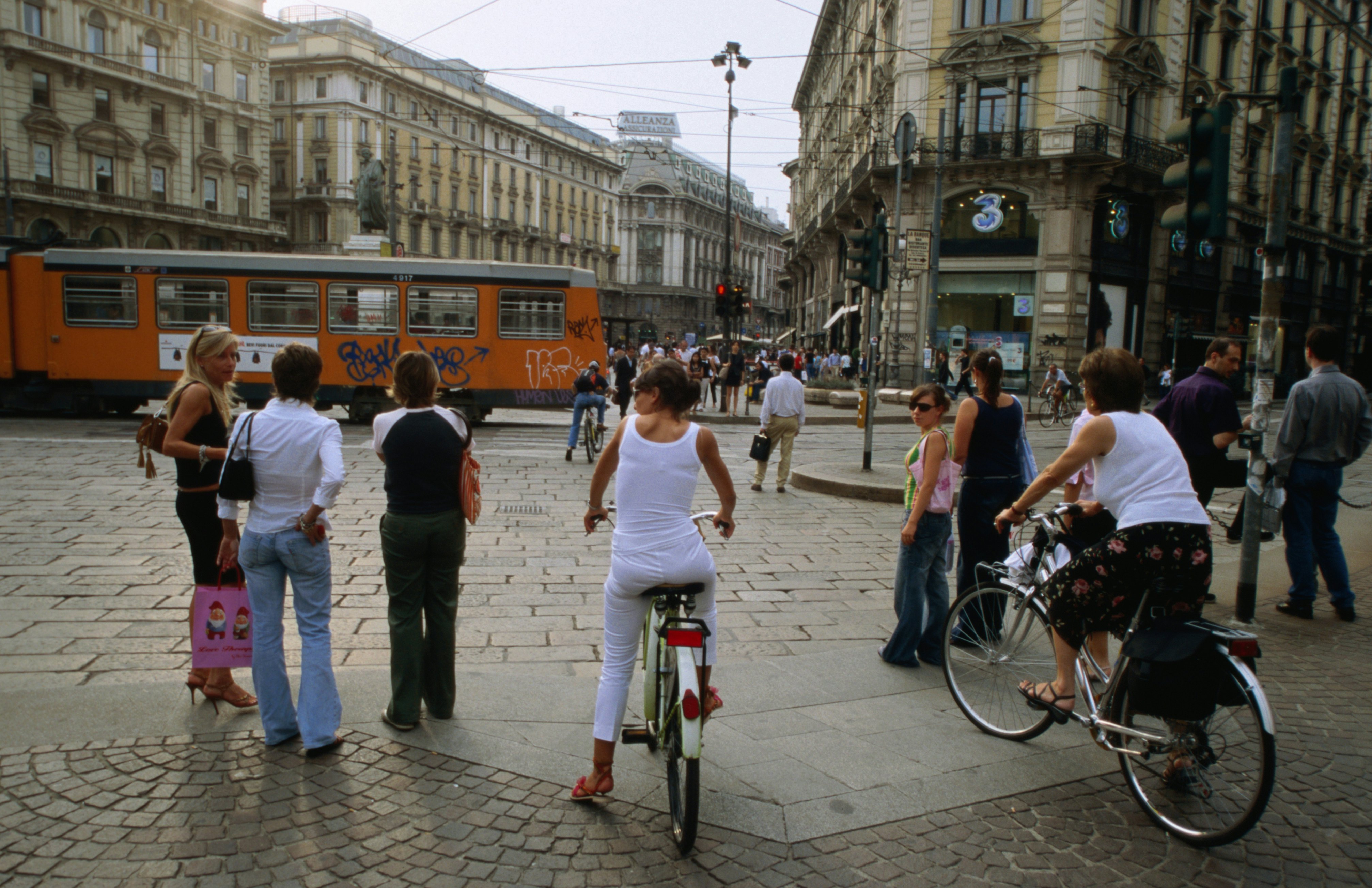 Pedestrians and cyclists on Piazza Cordusio, Milan.