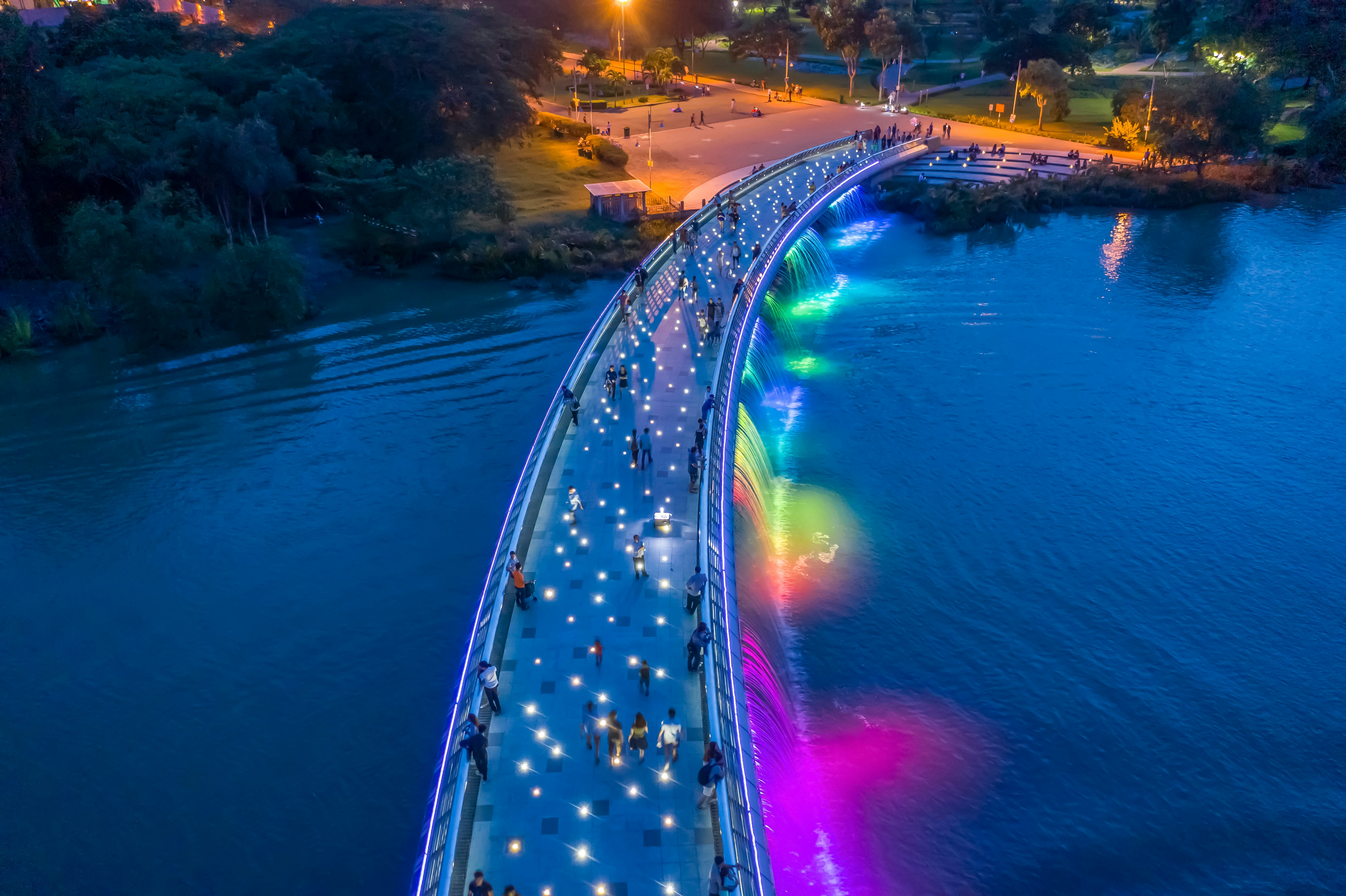 Starlight Bridge at night, with multicolored lights along the sides and white lights on the walking path.