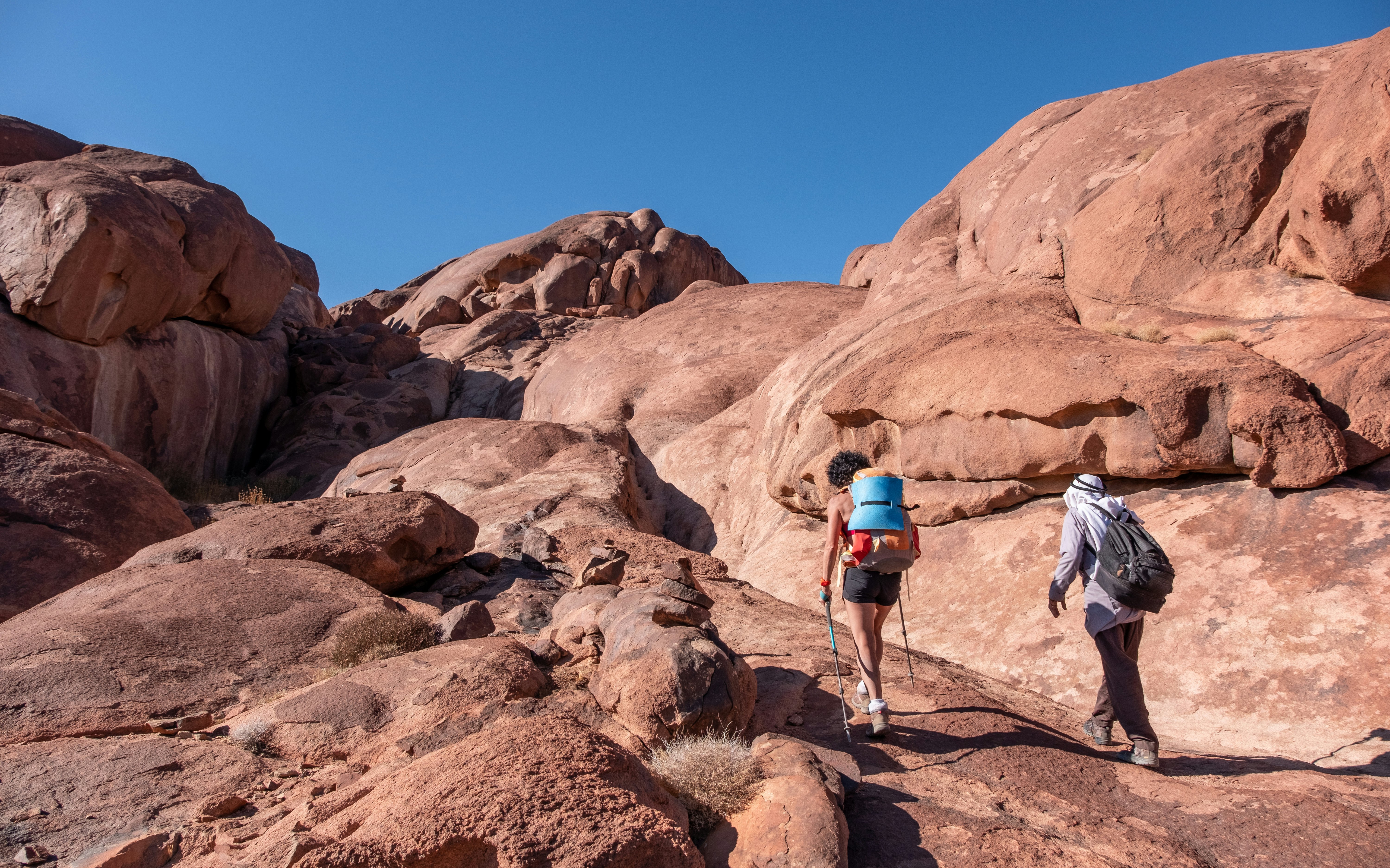 A hiker with a Bedouin guide on a rocky path in the South Sinai, Egypt.