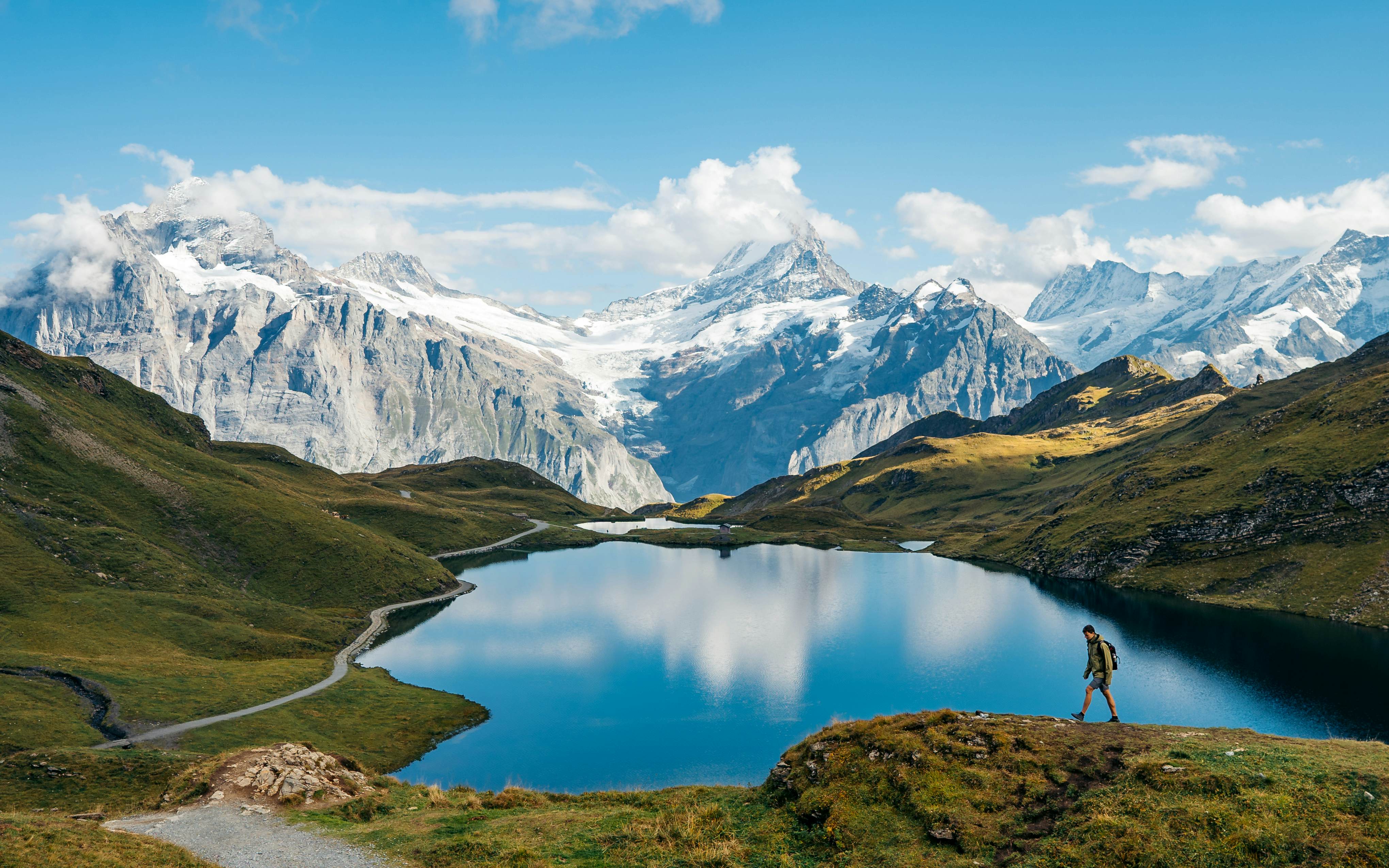 A hiker explores Lake Bachalpsee at Switzerland's Grindelwald. Location place Bachalpsee, Swiss alps, valley, Europe. Photo of popular tourist destination. Discover the beauty of earth.   License Type: media  Download Time: 2024-02-21T15:20:14.000Z  User:   Is Editorial: No  purchase_order:   