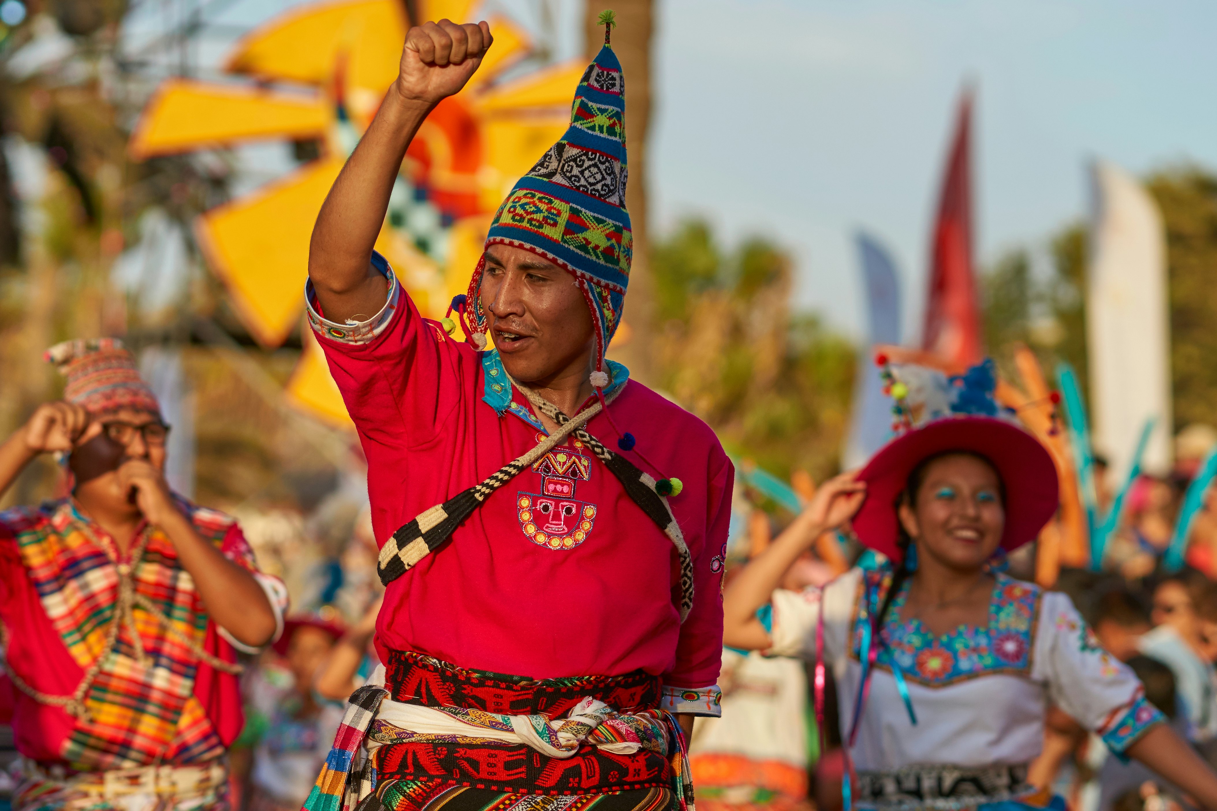 People in traditional costumes march in a parade during a summer festival.