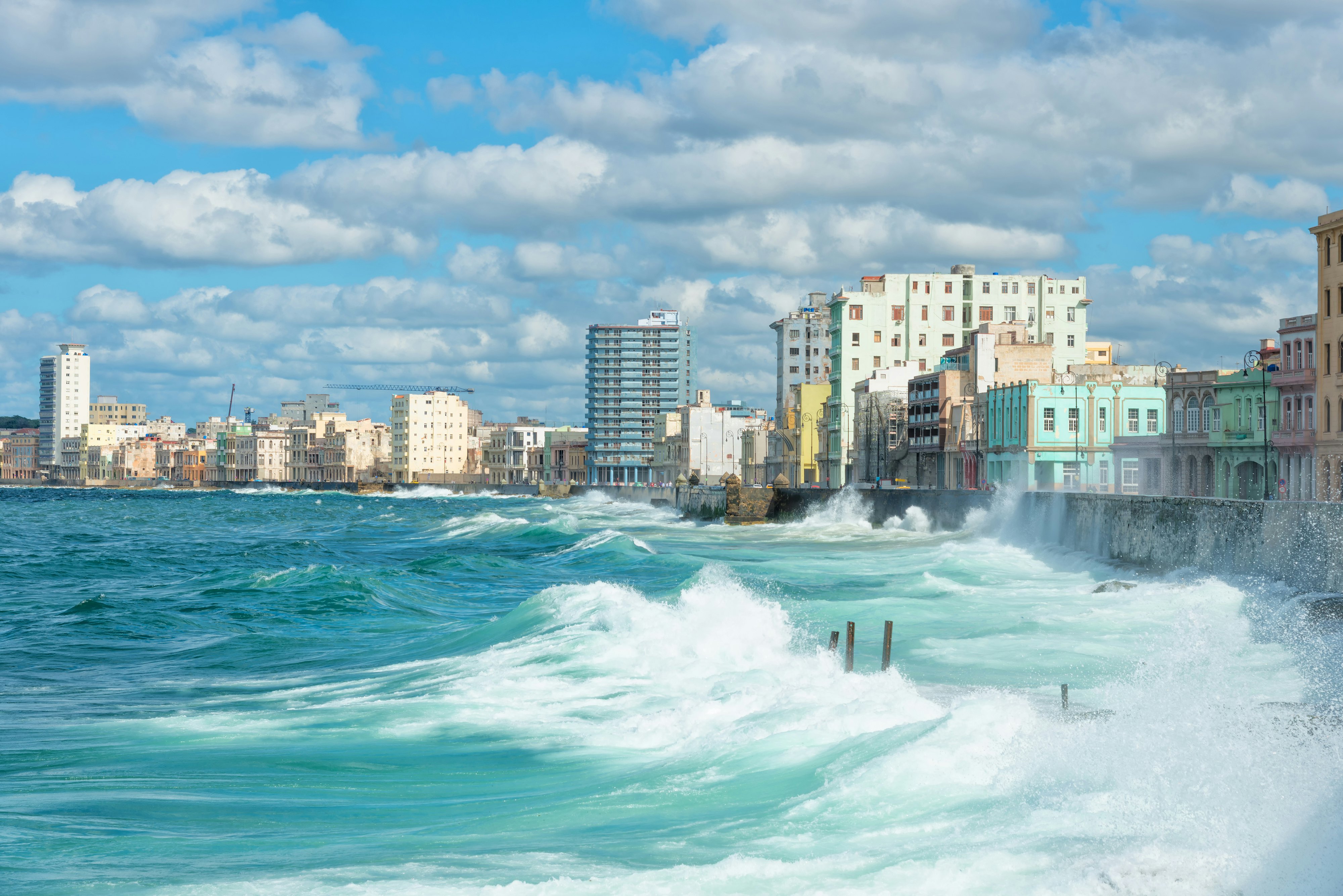Large waves hitting a city's sea wall.
