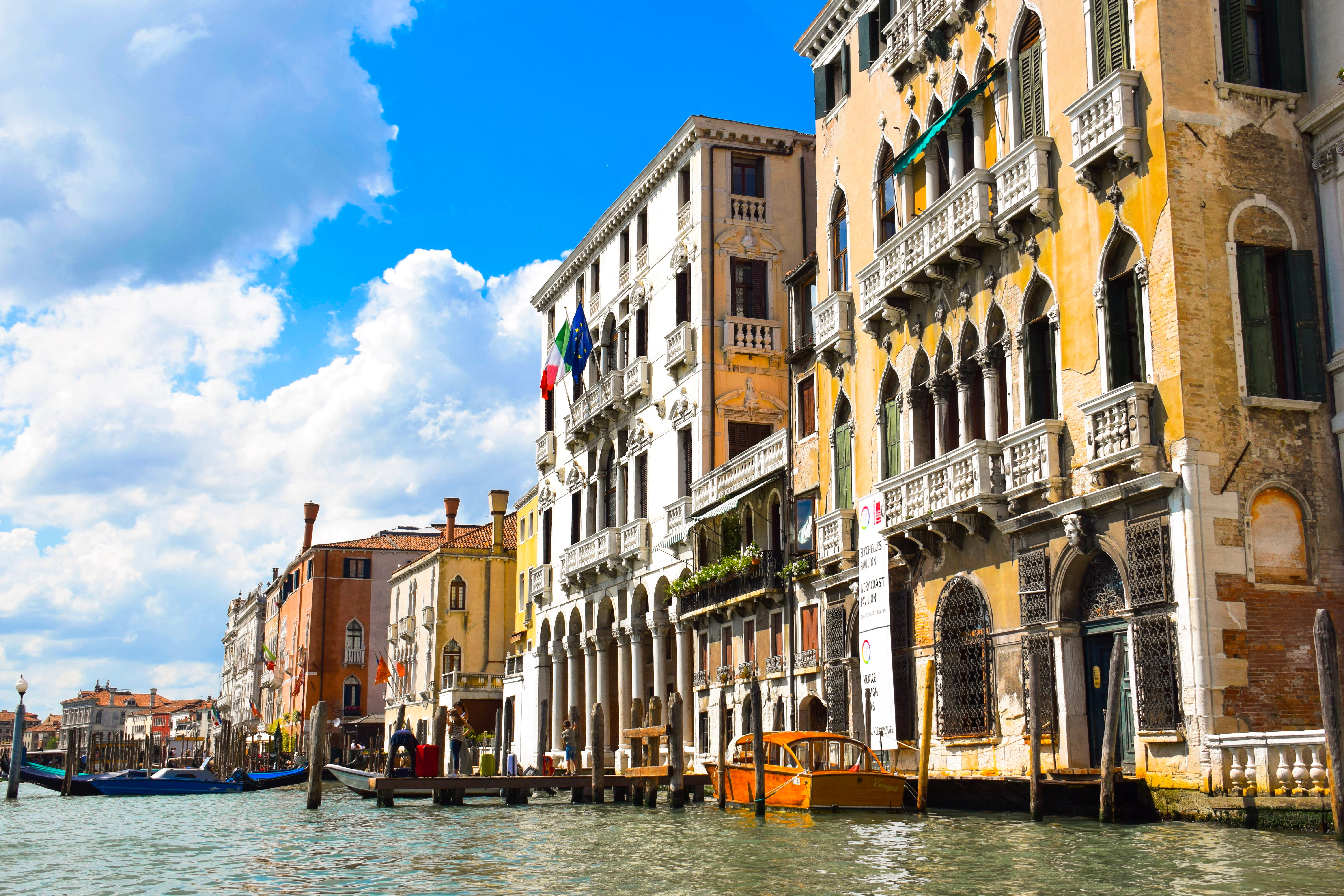 Tall villas rise beside a canal in Venice, Italy.