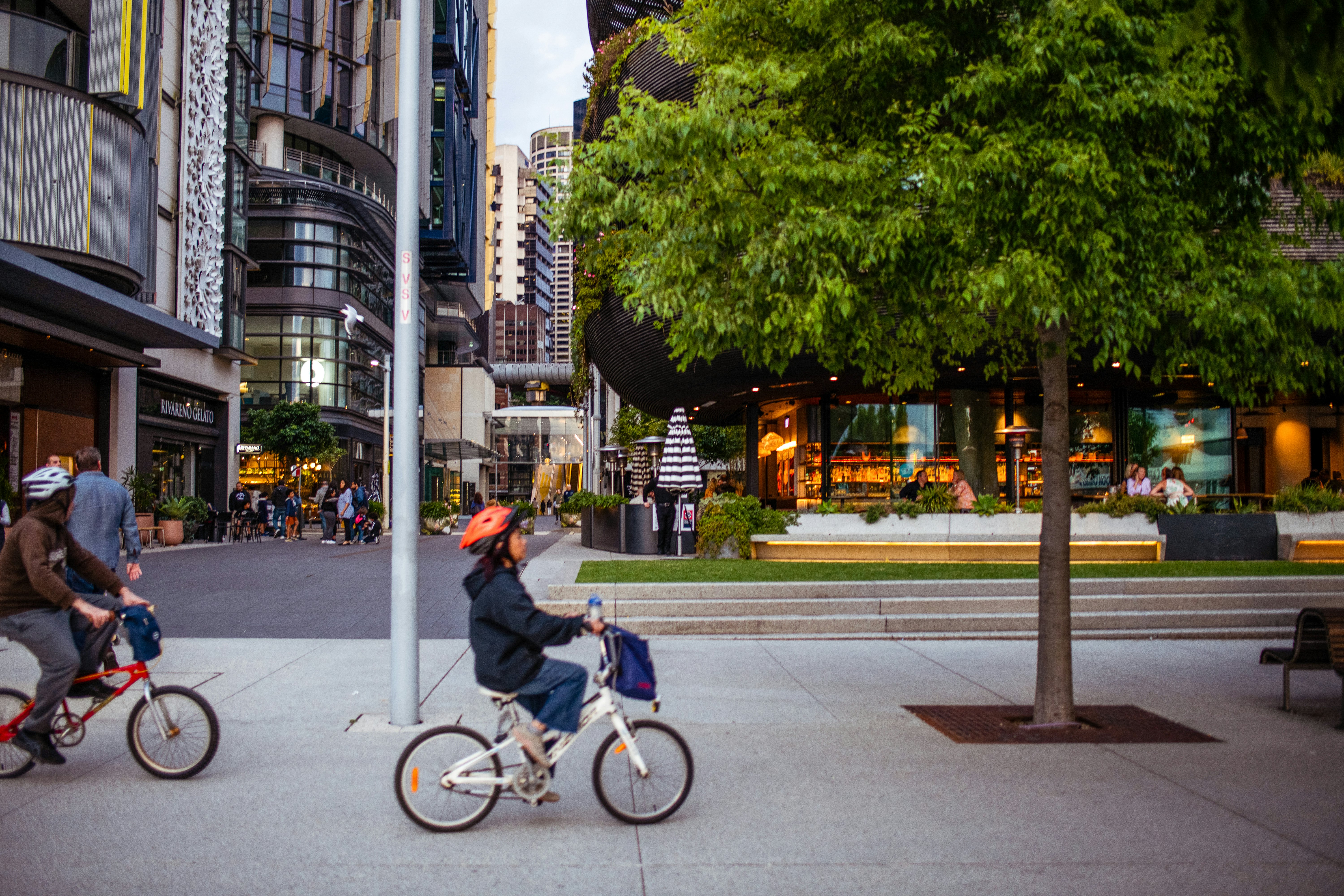People ride bikes through an urban downtown.