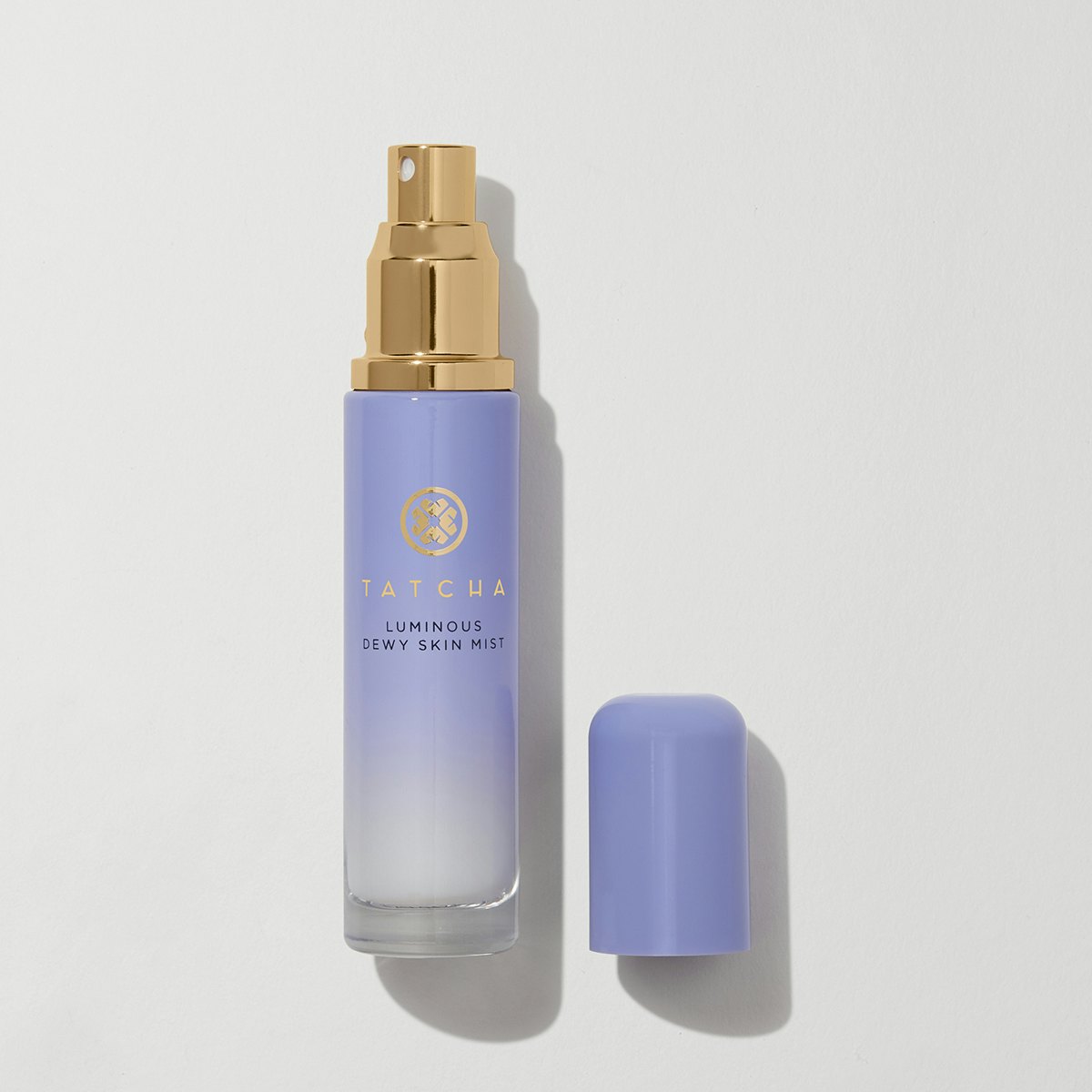 A purple bottle of skin mist with a brass atomizer