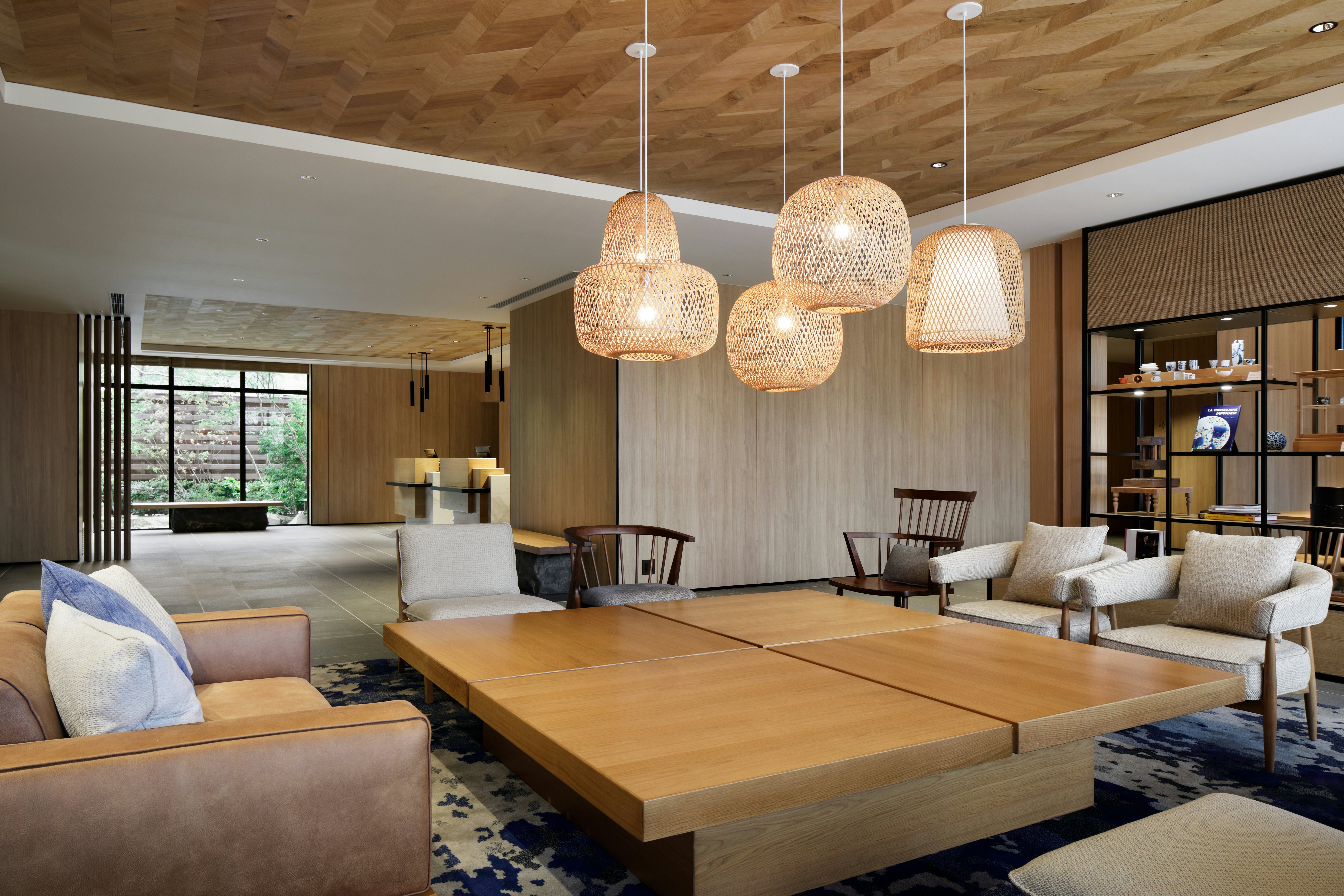 Lobby of a modern hotel with large, low coffee table surrounded by comfortable chairs.