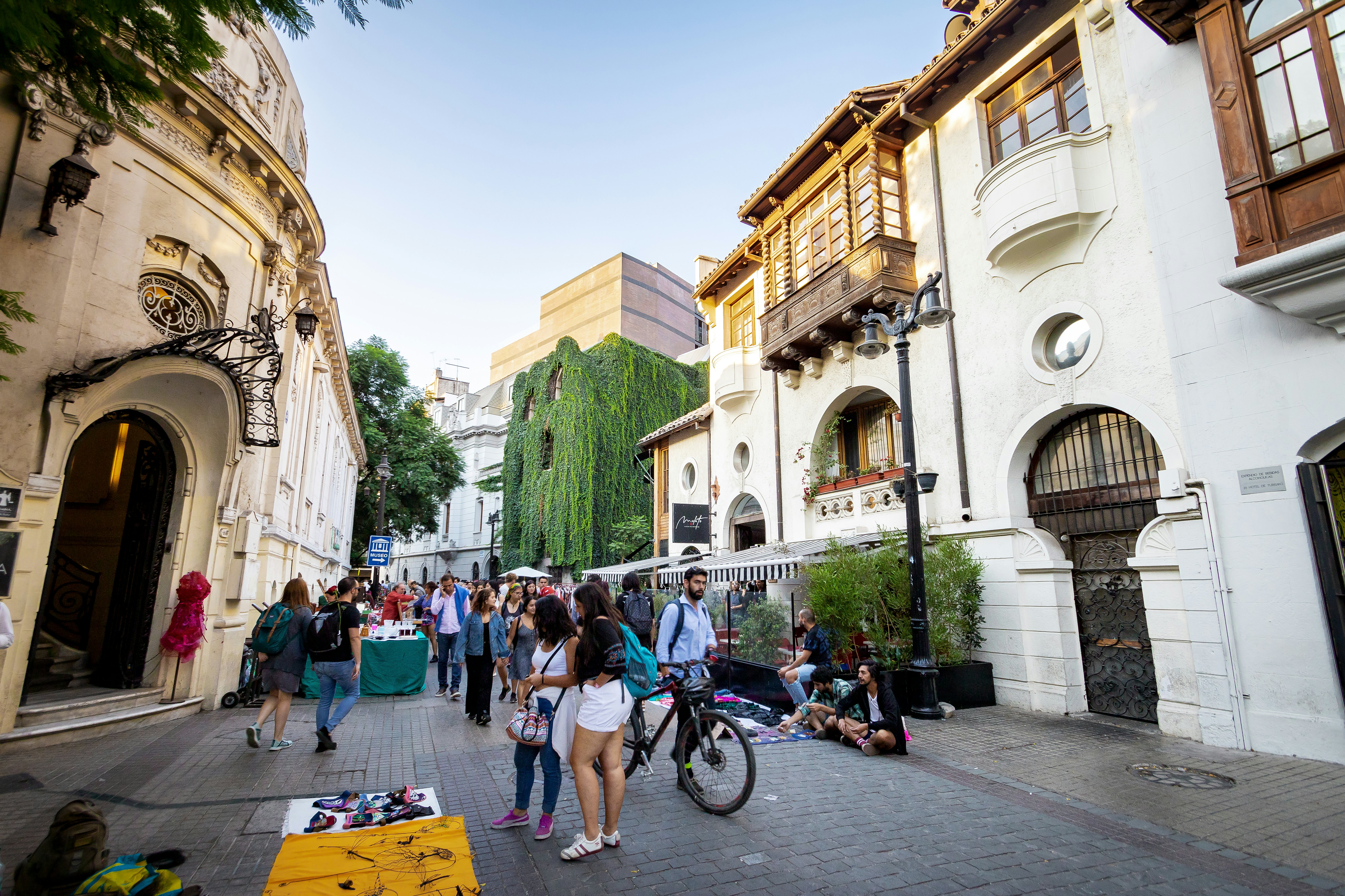People stroll on a pedestrian street with historic houses in a city.