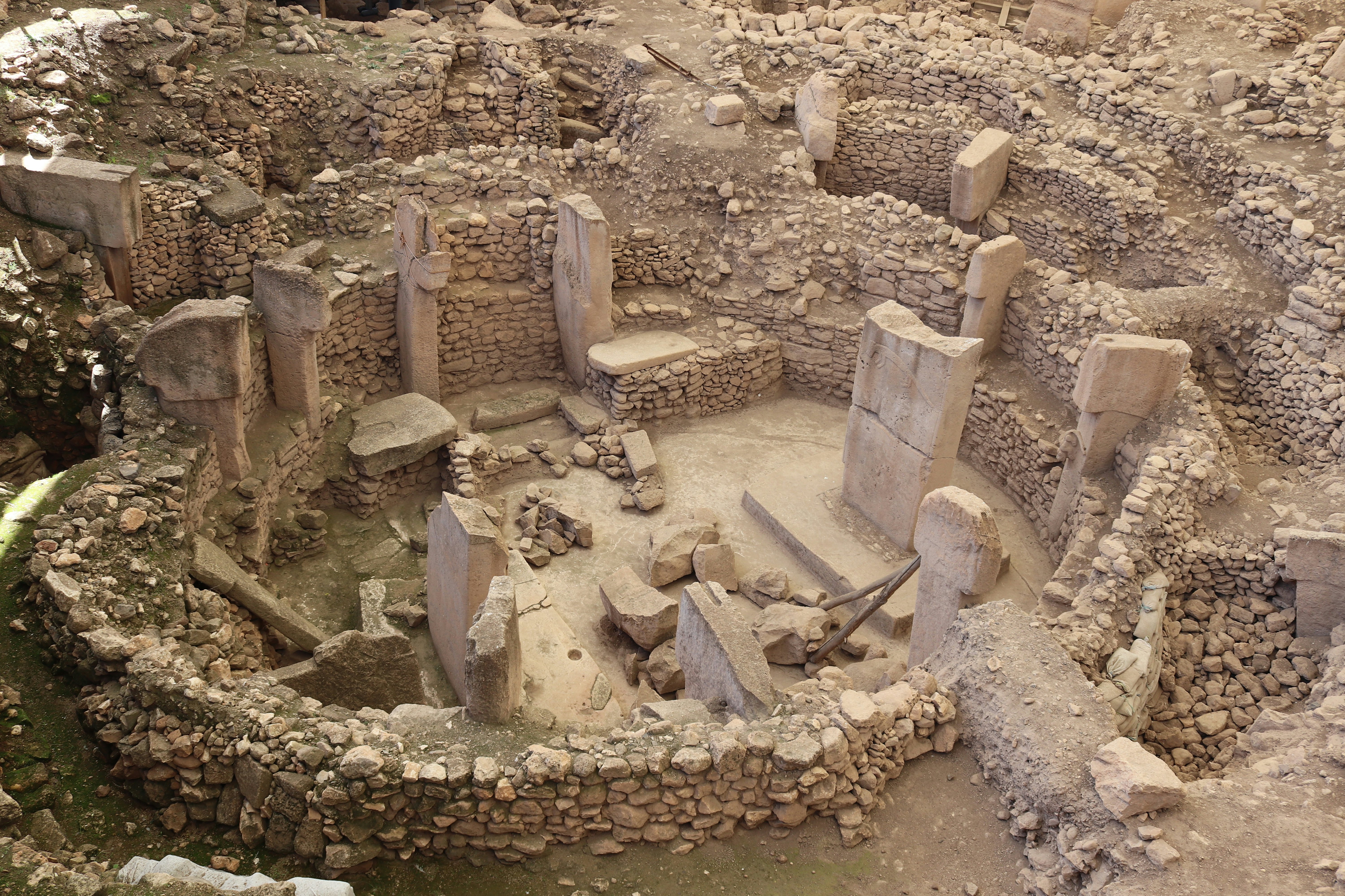 An aerial view of an ancient site in Türkiye with ruins surrounded by rock walls.