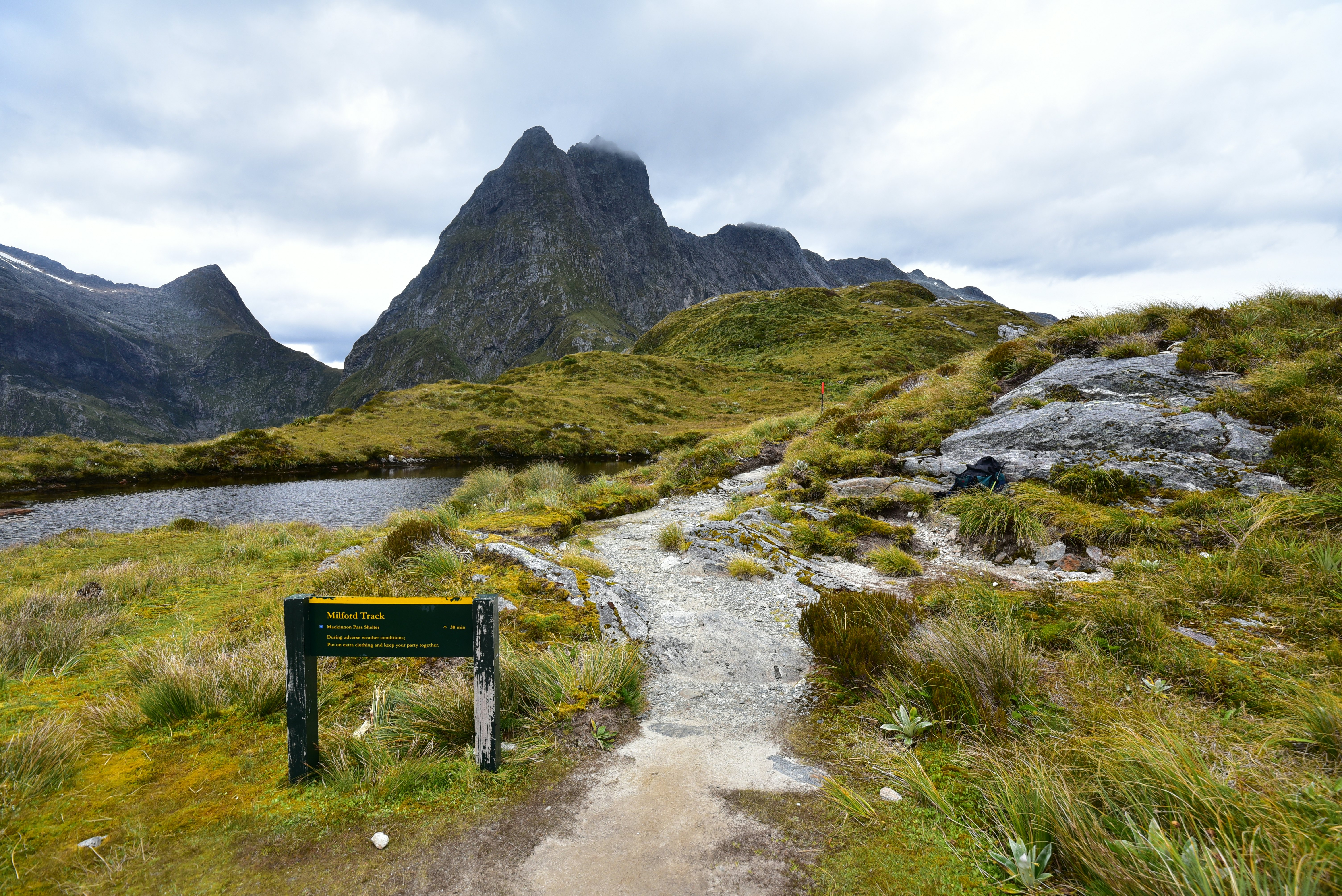 A stony pathway leads up a hill towards a mountain peak.