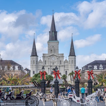 NEW ORLEANS, LA, USA - NOVEMBER 30, 2019: Cityscape photo with St. Louis Cathedral, the Cabildo, the Presbytere, mule-drawn carriages, and Christmas decorations on Jackson Square, License Type: media, Download Time: 2025-11-12T14:11:06.000Z, User: clairenaylor, Editorial: true, purchase_order: 65050 - Digital Destinations and Articles, job: online editorial, client: New Orleans Christmas, other: Claire Naylor