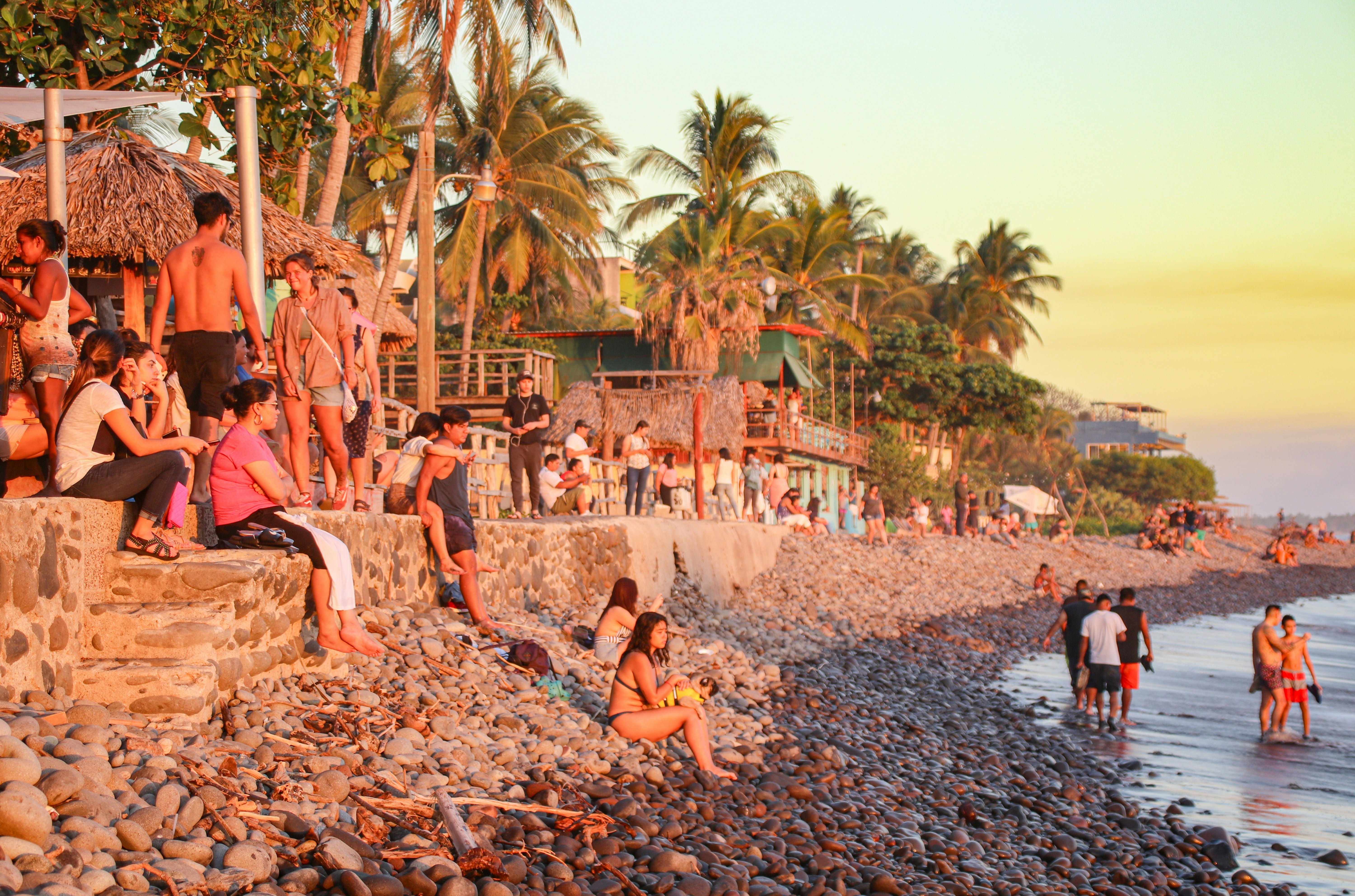 Locals and tourists enjoying the sunset over the Pacific Ocean at El Tunco.