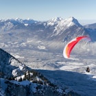 HOCHALM, AUSTRIA - 13 January 2024: A paraglider flying over a winter landscape in Salzburg, Austria. He started from the mountain station Untersberg, Salzburg. , License Type: media, Download Time: 2025-11-03T21:18:43.000Z, User: carolfarrell170, Editorial: false, purchase_order: 56530 - Guidebooks, job: Global Publishing WIP, client: Austria 12, other: carol farrell