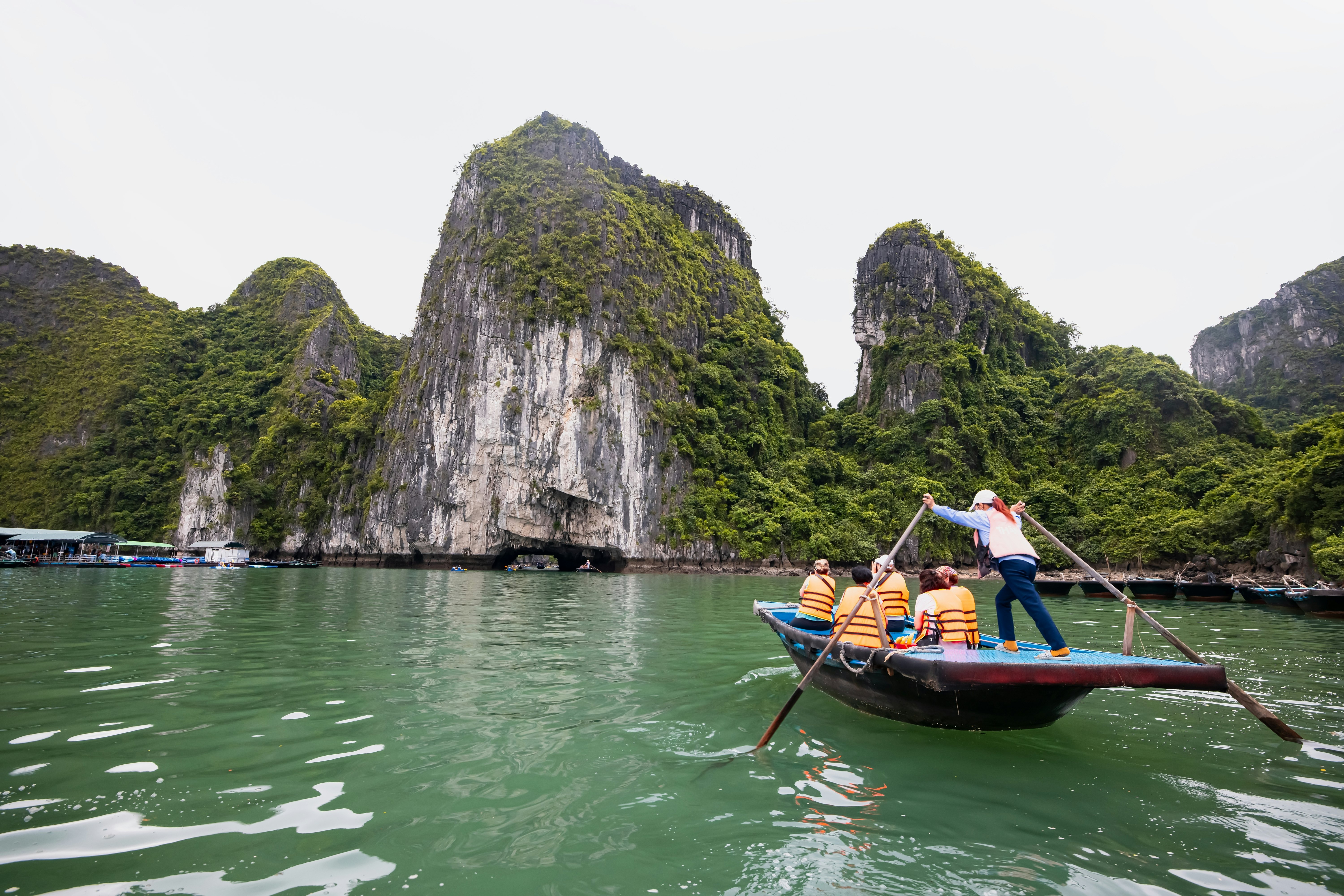 People in a boat on Halong Bay with one person rowing
