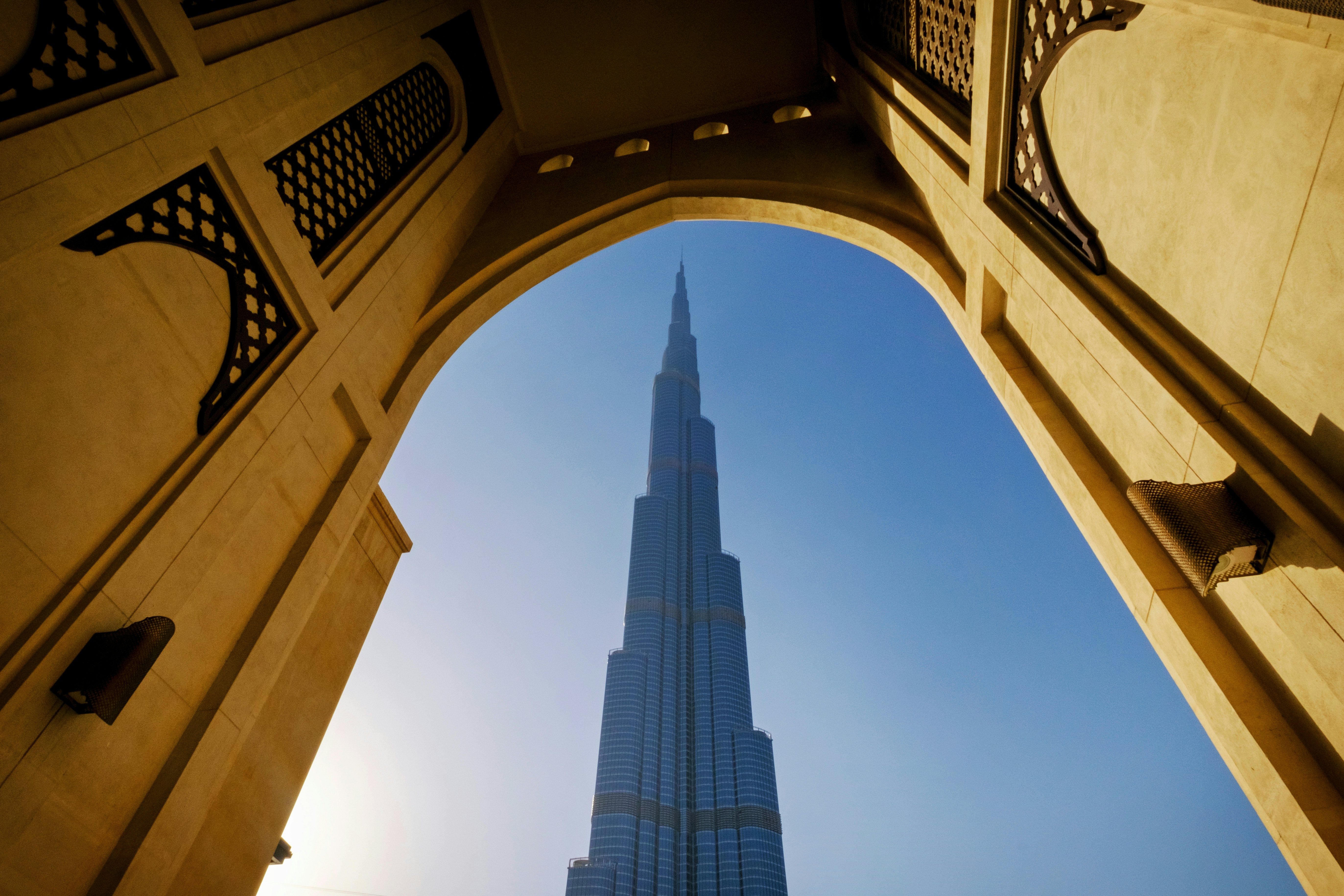 A modern skyscraper is framed by an archway in Dubai, United Arab Emirates.