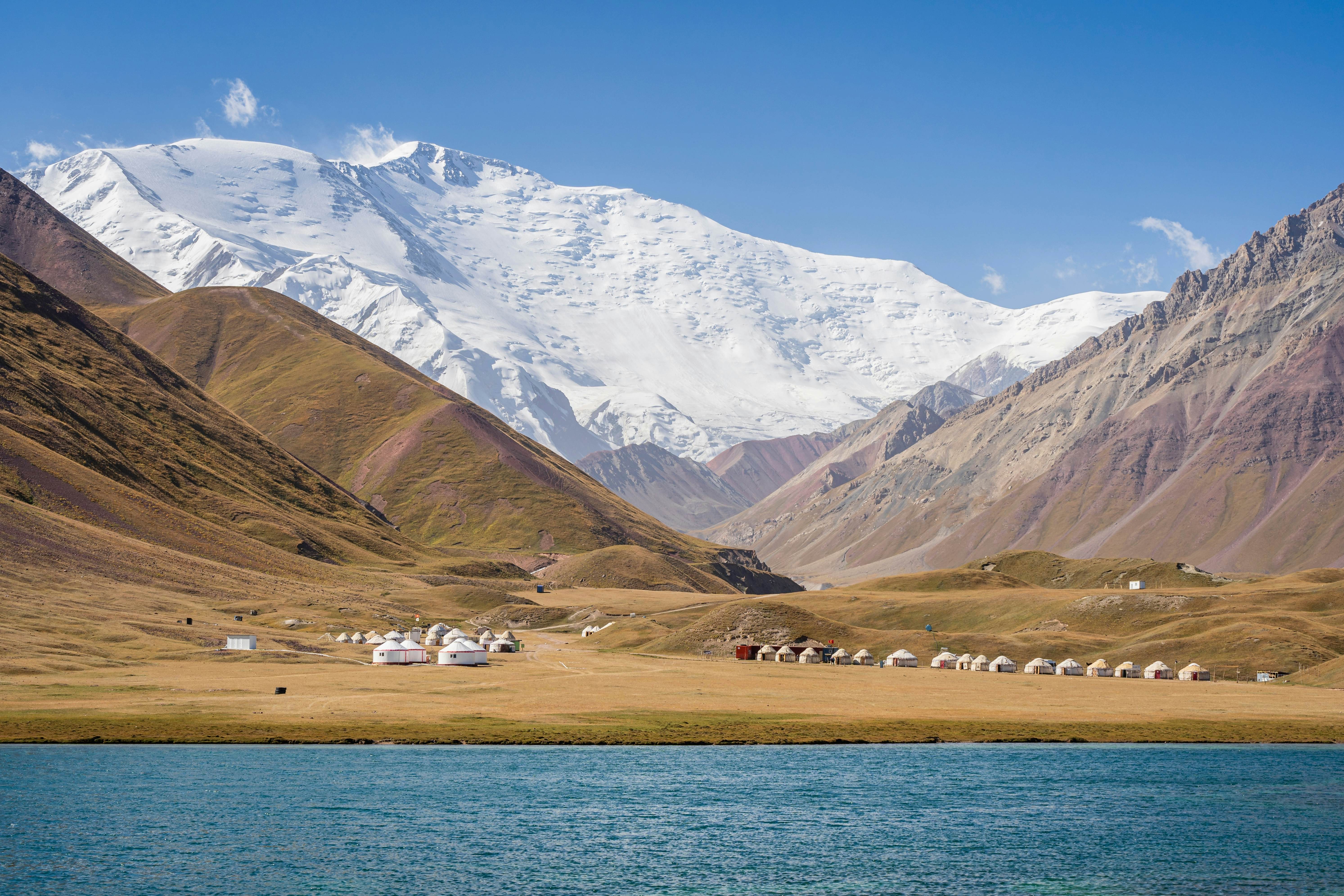 Scenic landscape view of snowcapped Lenin Peak aka Ibn Sina peak in Trans Alay mountain range with lake Tulpar Kul and yurt camp, Sary Mogul, Kyrgyzstan, License Type: media, Download Time: 2025-06-19T16:56:15.000Z, User: catalinaaragon, Editorial: false, purchase_order: 56530 - Guidebooks, job: Global Publishing WIP, client: Central Asia 8, other: Central Asia 8