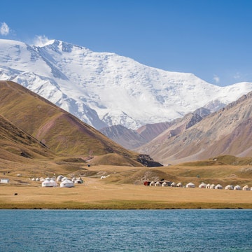 Scenic landscape view of snowcapped Lenin Peak aka Ibn Sina peak in Trans Alay mountain range with lake Tulpar Kul and yurt camp, Sary Mogul, Kyrgyzstan, License Type: media, Download Time: 2025-06-19T16:56:15.000Z, User: catalinaaragon, Editorial: false, purchase_order: 56530 - Guidebooks, job: Global Publishing WIP, client: Central Asia 8, other: Central Asia 8