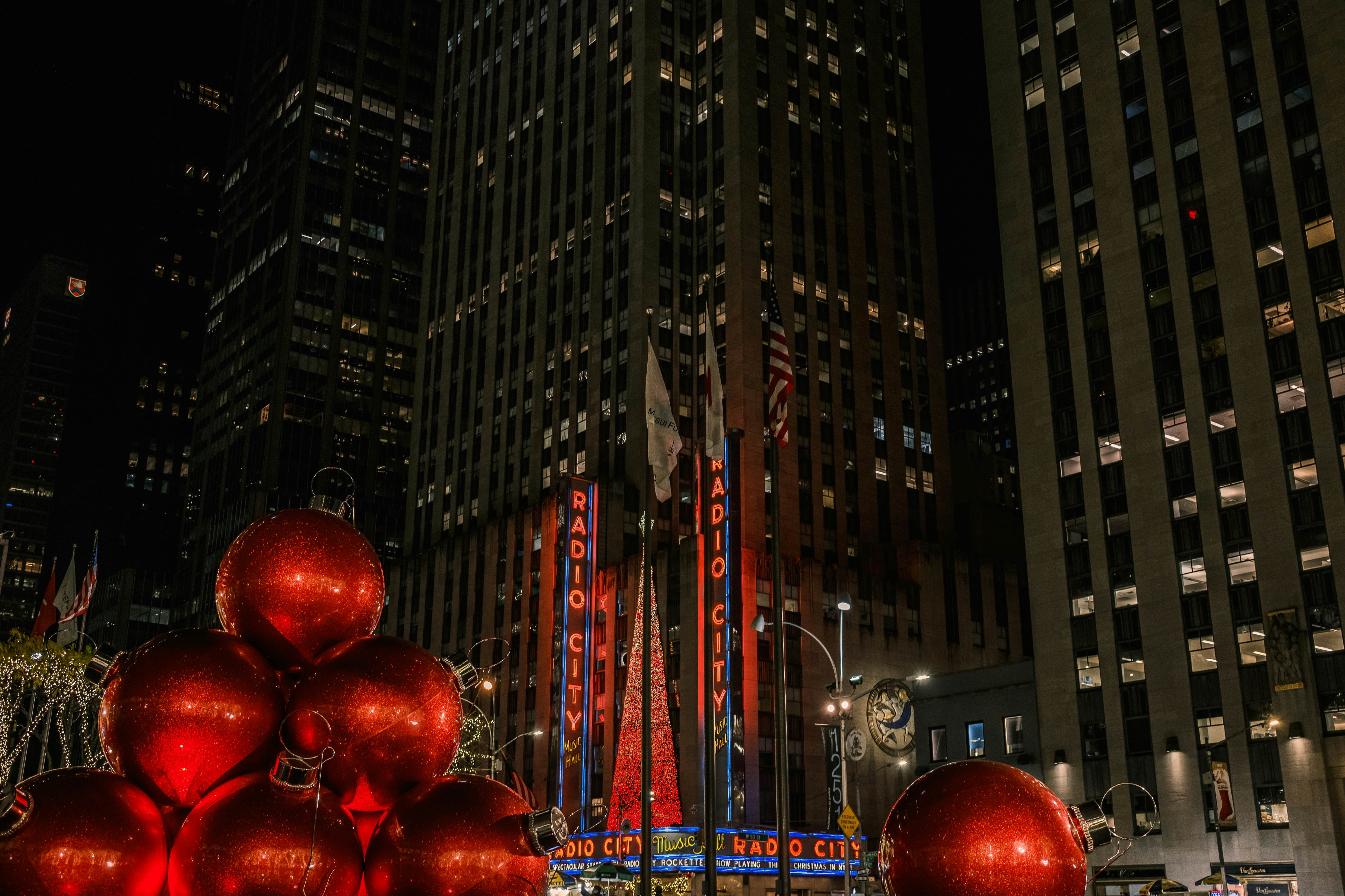 New York City - November 25, 2024: large Christmas spheres on a fountain, with the famous Radio City Music Hall building in the background, and its Christmas tree, located on Sixth Avenue, Manhattan, License Type: media, Download Time: 2025-11-18T21:44:55.000Z, User: adouglaslott59, Editorial: true, purchase_order: 65050 - Digital Destinations and Articles, job: Online editorial, client: Ultimate Christmas weekend in Manhattan, other: Ann Douglas Lott