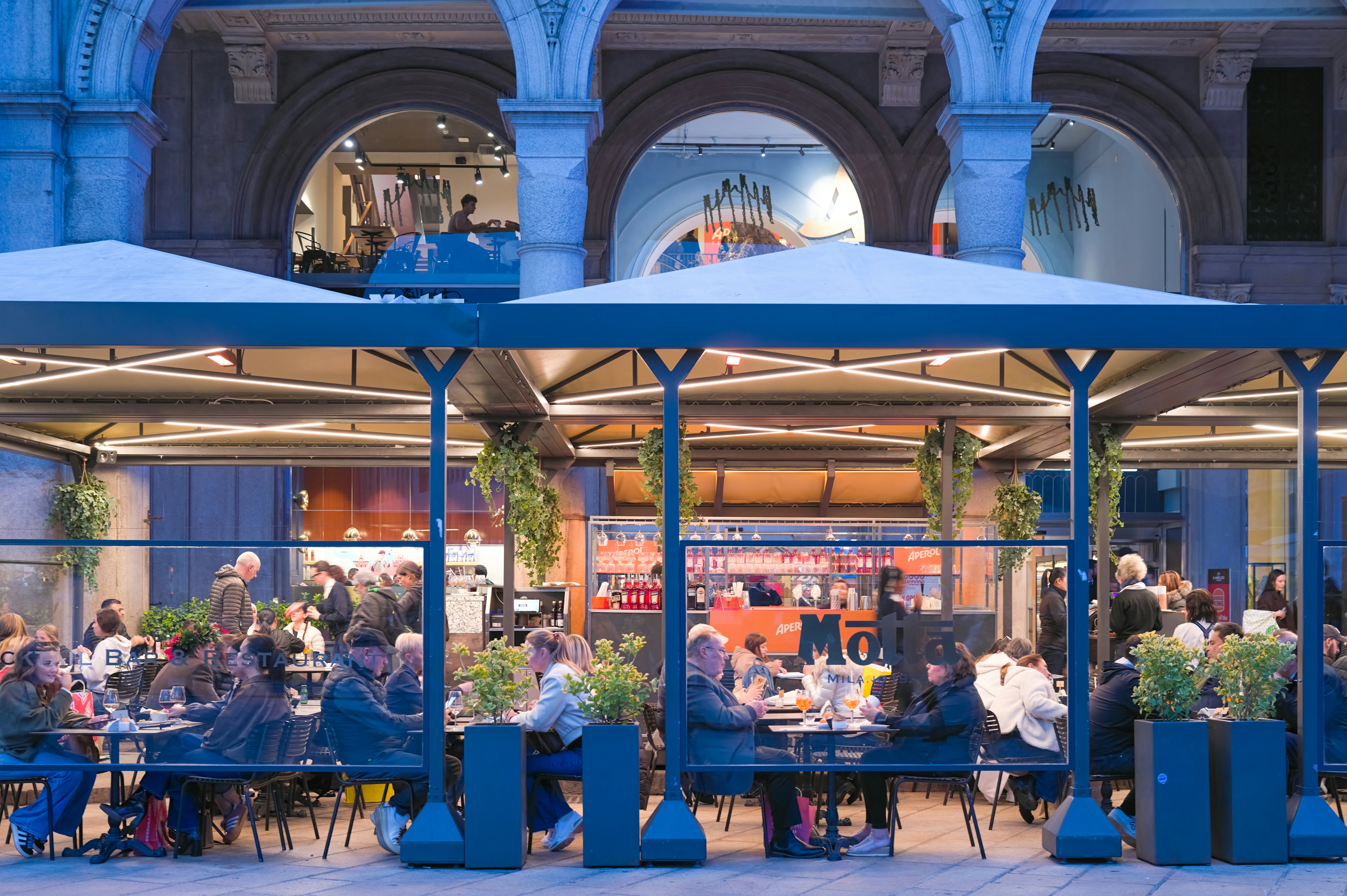 People at a streetside cafe in an upmarket neighborhood.