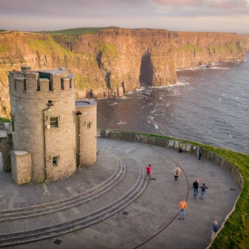 Cliffs of Moher at the west coast of Ireland with a little castle during sunset with flowers. Travel to Ireland in Europe., License Type: media, Download Time: 2025-11-05T18:40:29.000Z, User: katelyn.perry_lonelyplanet, Editorial: false, purchase_order: 65050 - Digital Destinations and Articles, job: wip, client: wip, other: Katelyn Perry