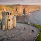 Cliffs of Moher at the west coast of Ireland with a little castle during sunset with flowers. Travel to Ireland in Europe., License Type: media, Download Time: 2025-11-05T18:40:29.000Z, User: katelyn.perry_lonelyplanet, Editorial: false, purchase_order: 65050 - Digital Destinations and Articles, job: wip, client: wip, other: Katelyn Perry