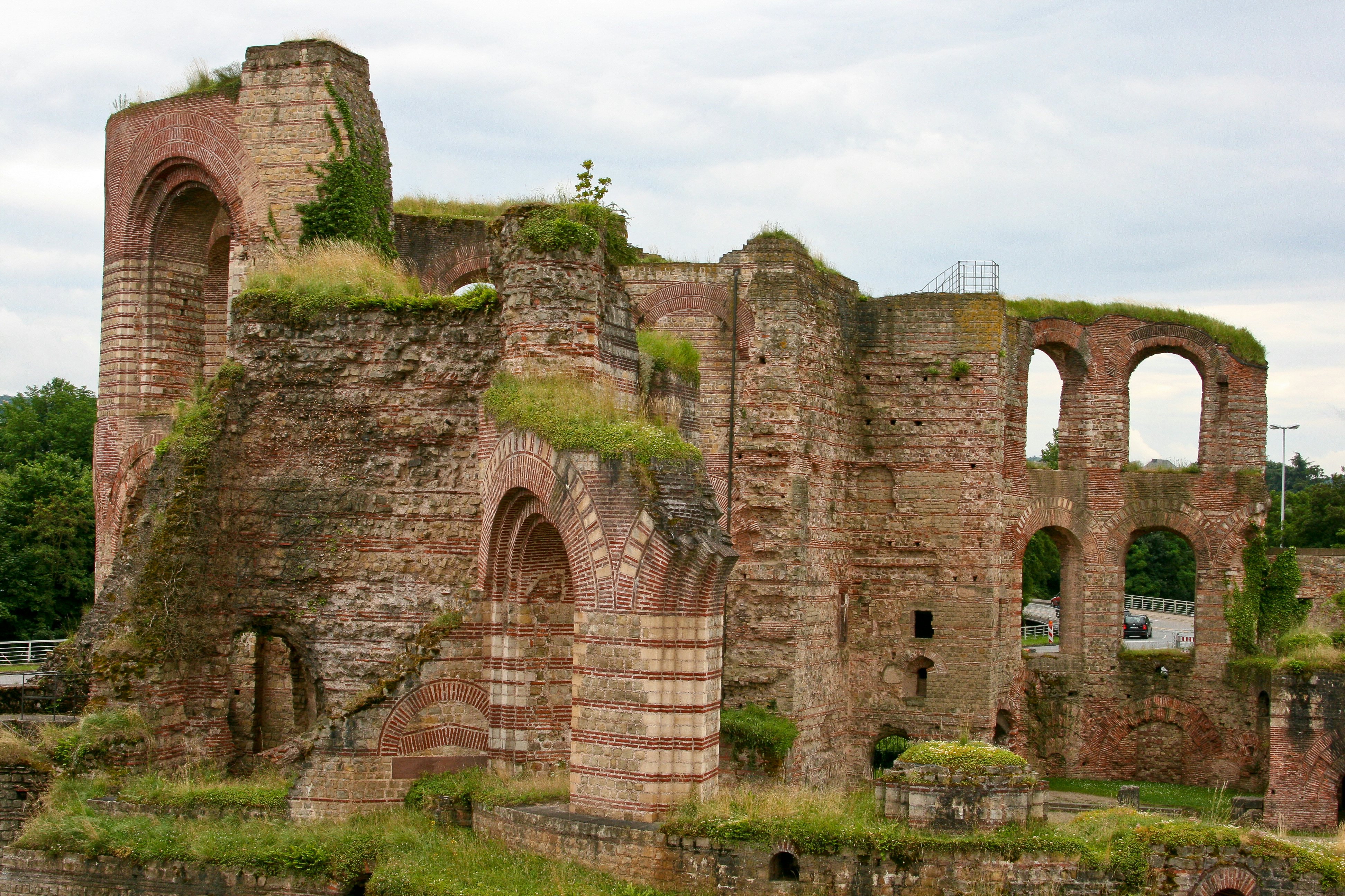 The brick ruins of an ancient bathhouse with large archways among its crumbling walls.