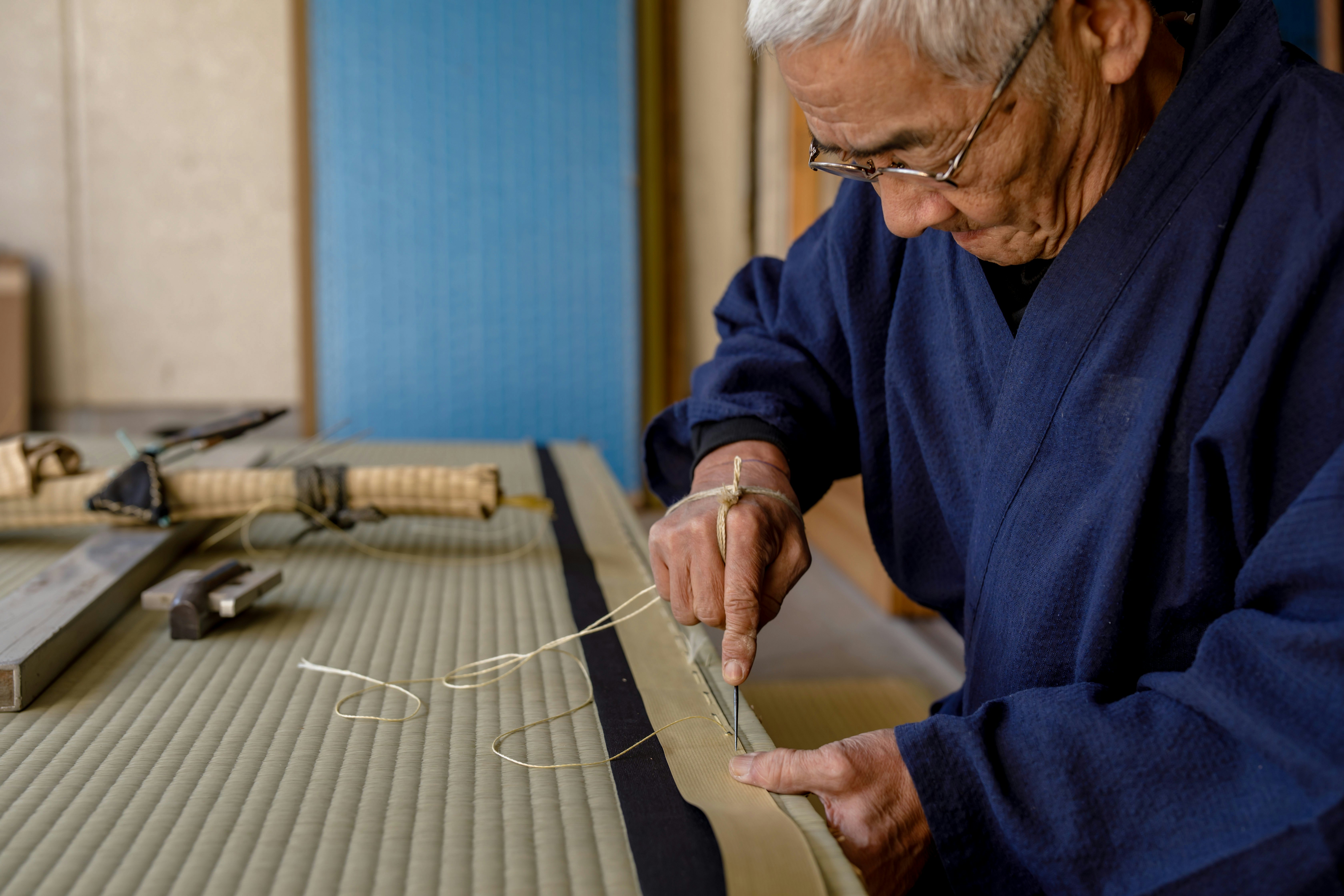 Shokunin Syunzi Ooe crafts a traditional tatami mat. Courtesy of Wabunka