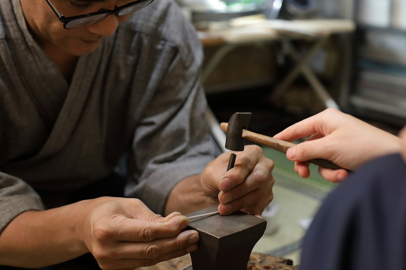 Yoshitsugu Kamikawa helps a participant make a silver bangle