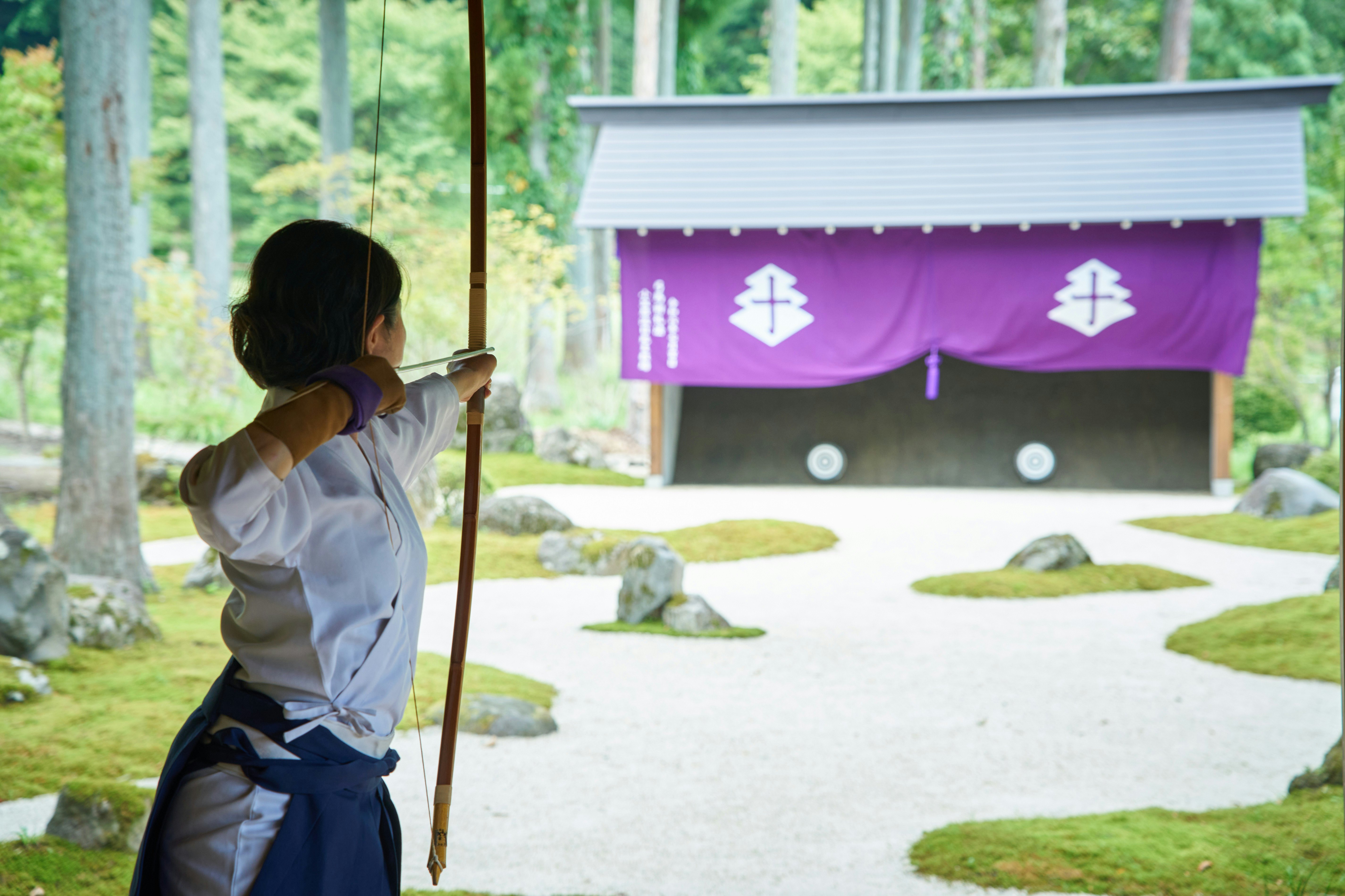 A woman takes aim on a traditional archery field