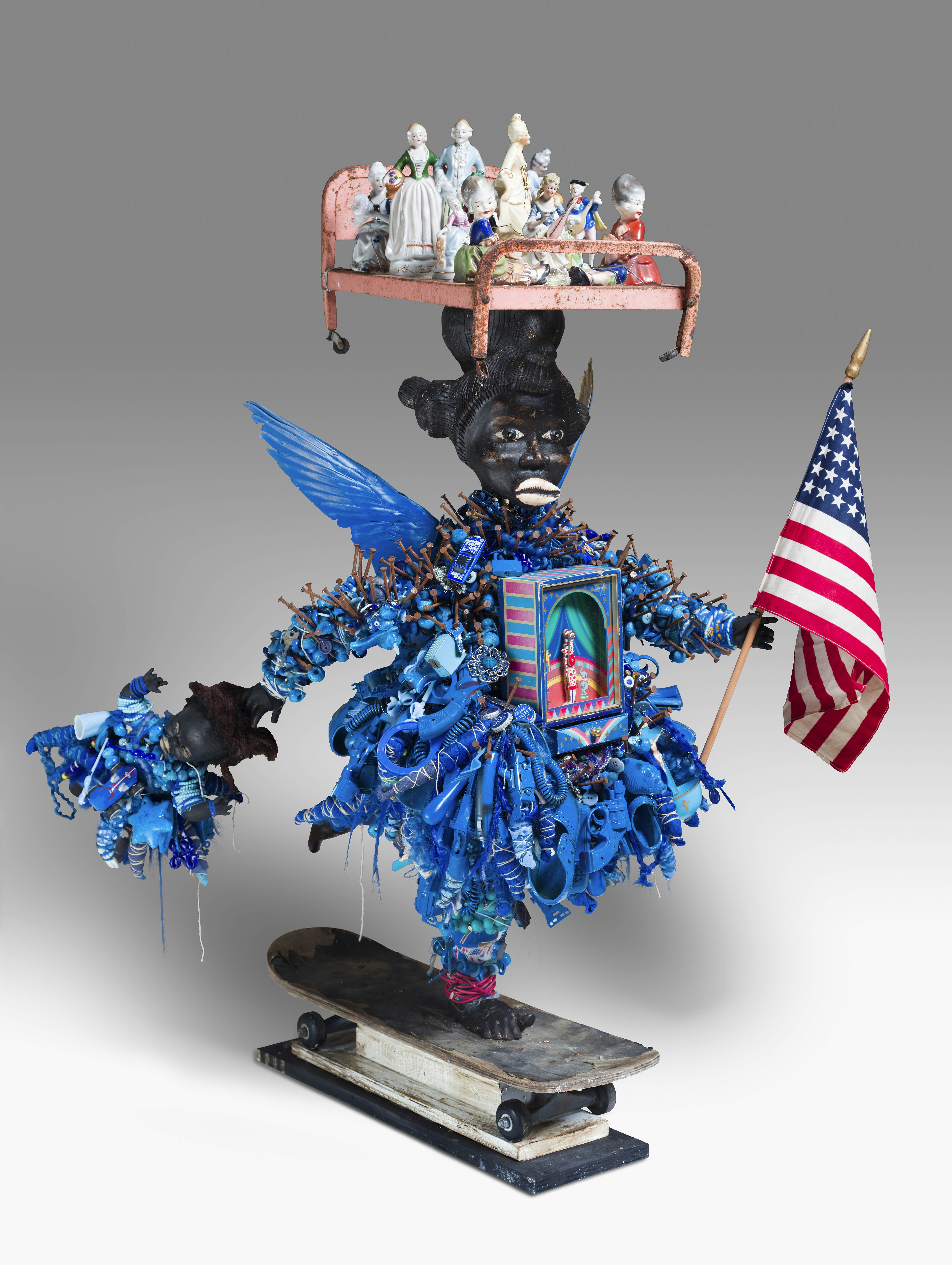 A multimedia sculpture depicts a figure holding an American flag among many other details.
