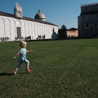Maggie running across the lawn of Piazza del Duomo, Pisa
