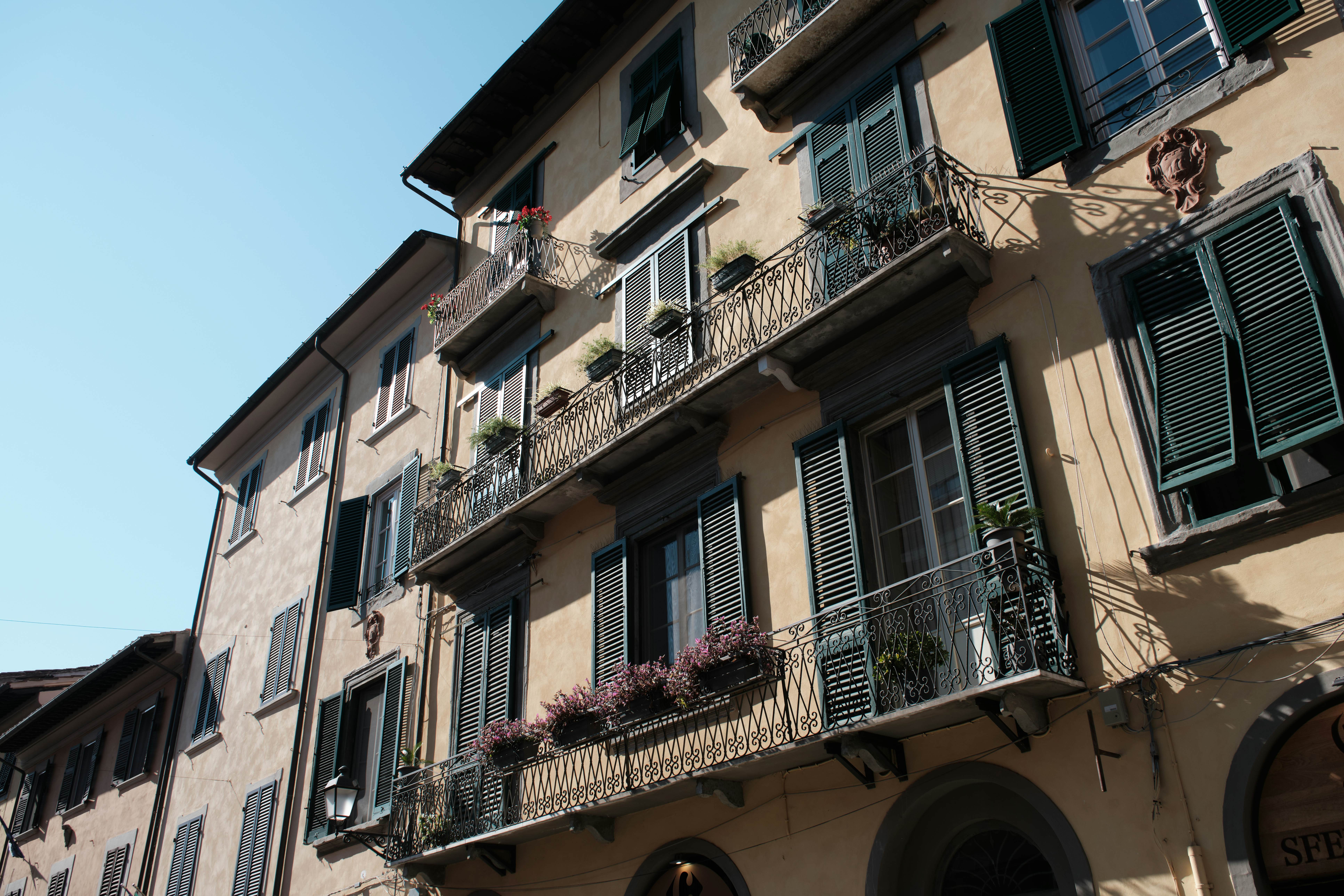 Apartments in a city with wrought-iron balconies and shuttered windows.