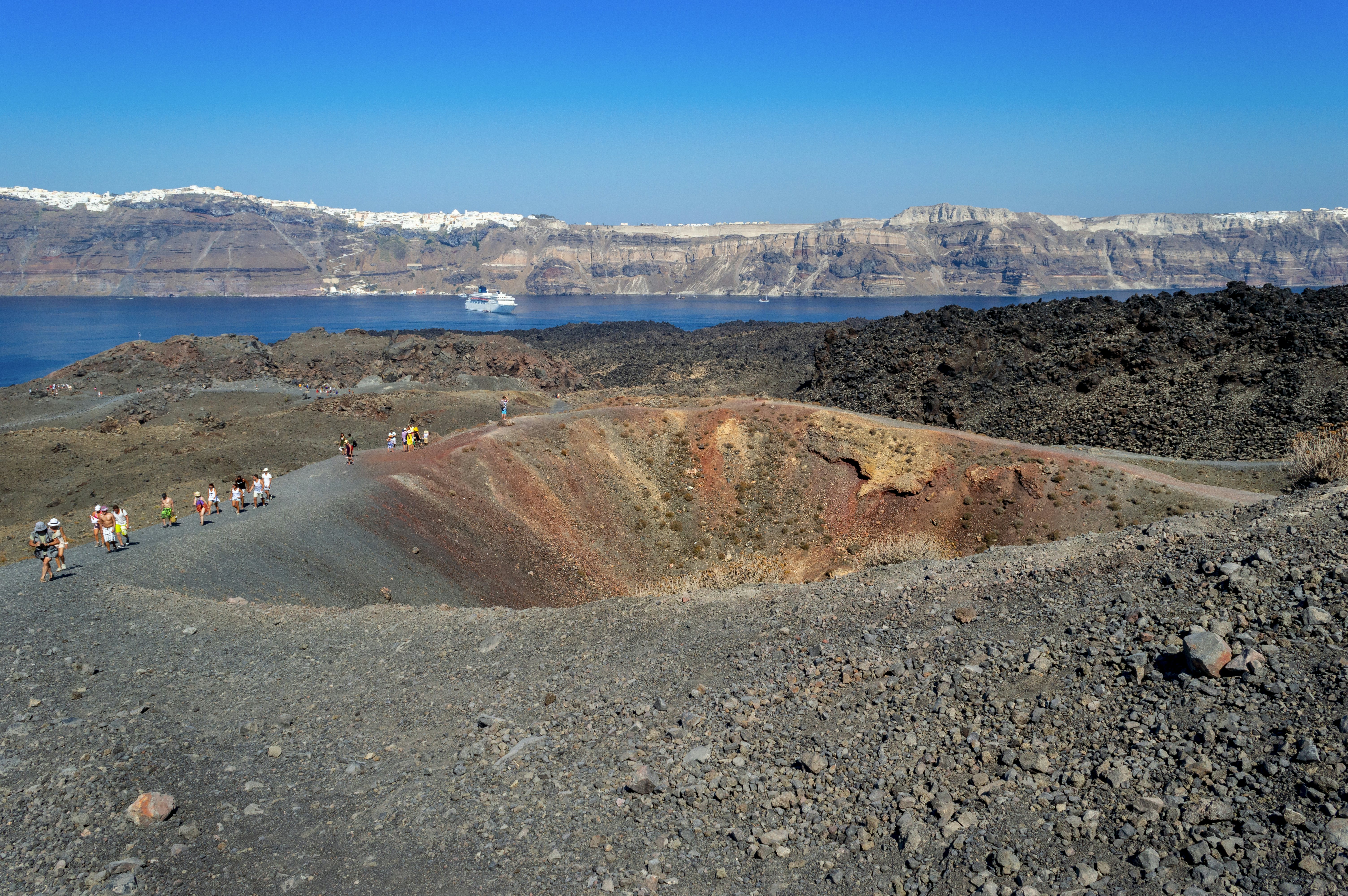 People walking along the edge of a volcanic crater