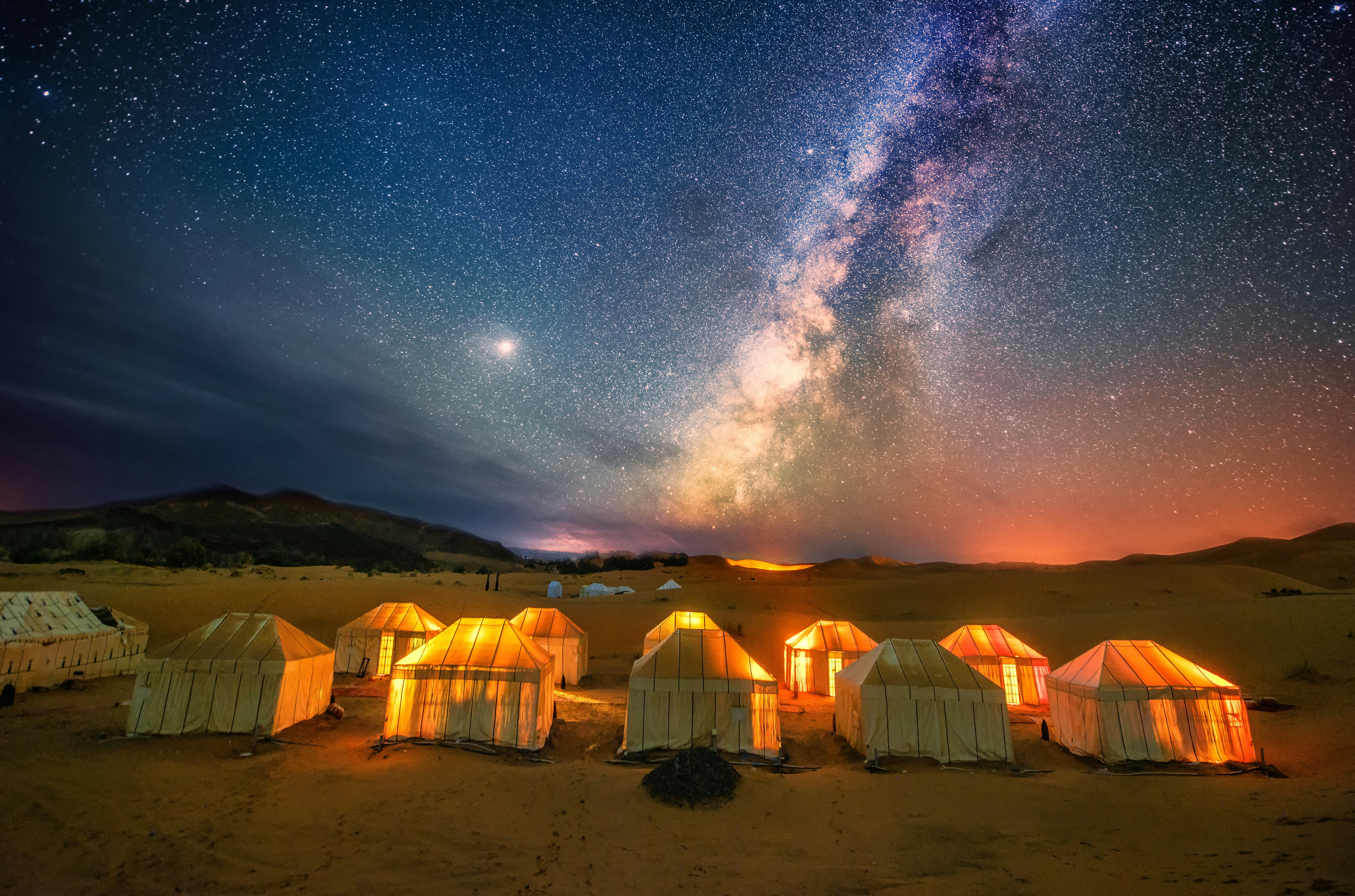 Tents and the glow of the milky way in a desert