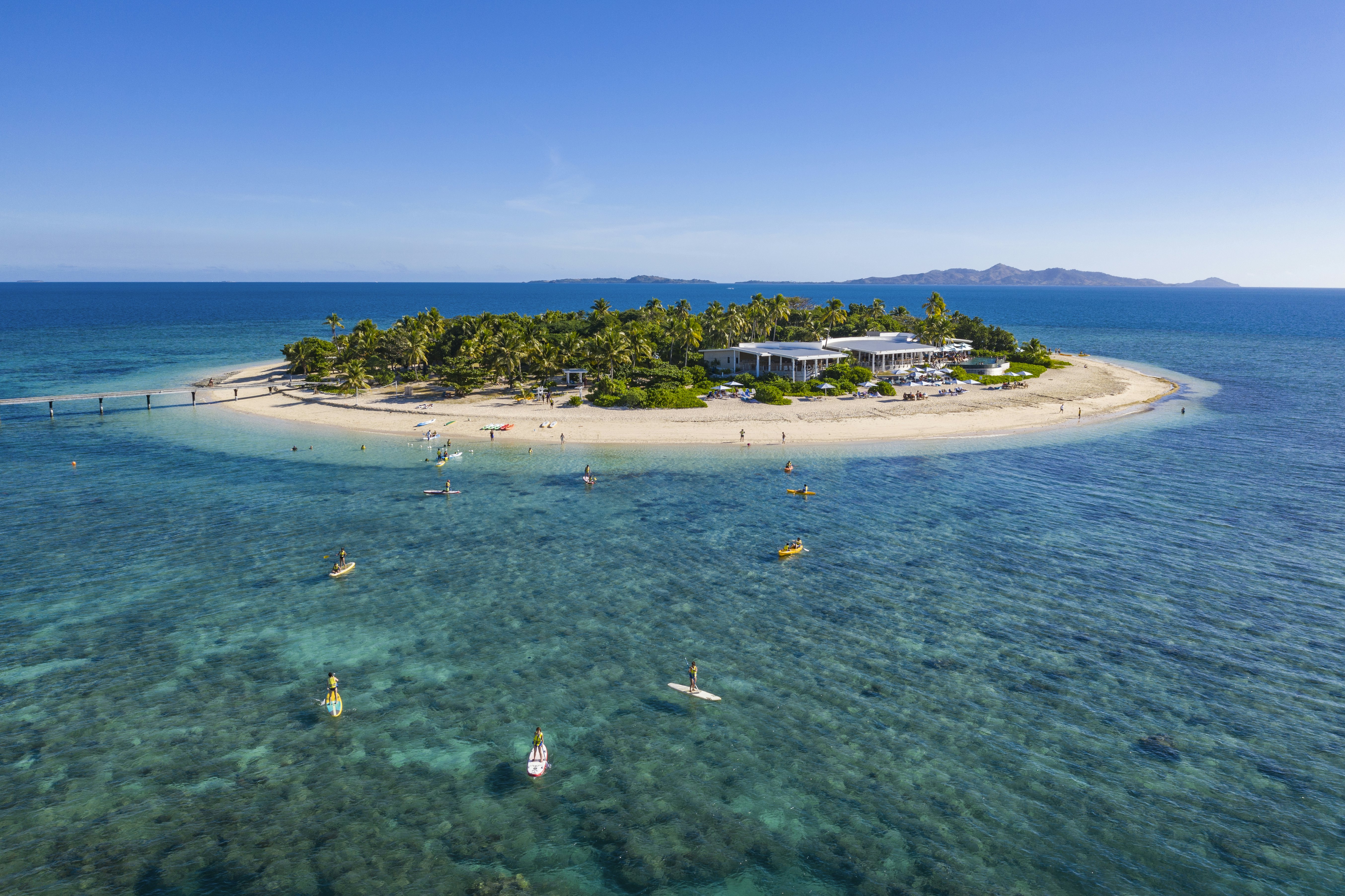 People on paddle boards outside a small island