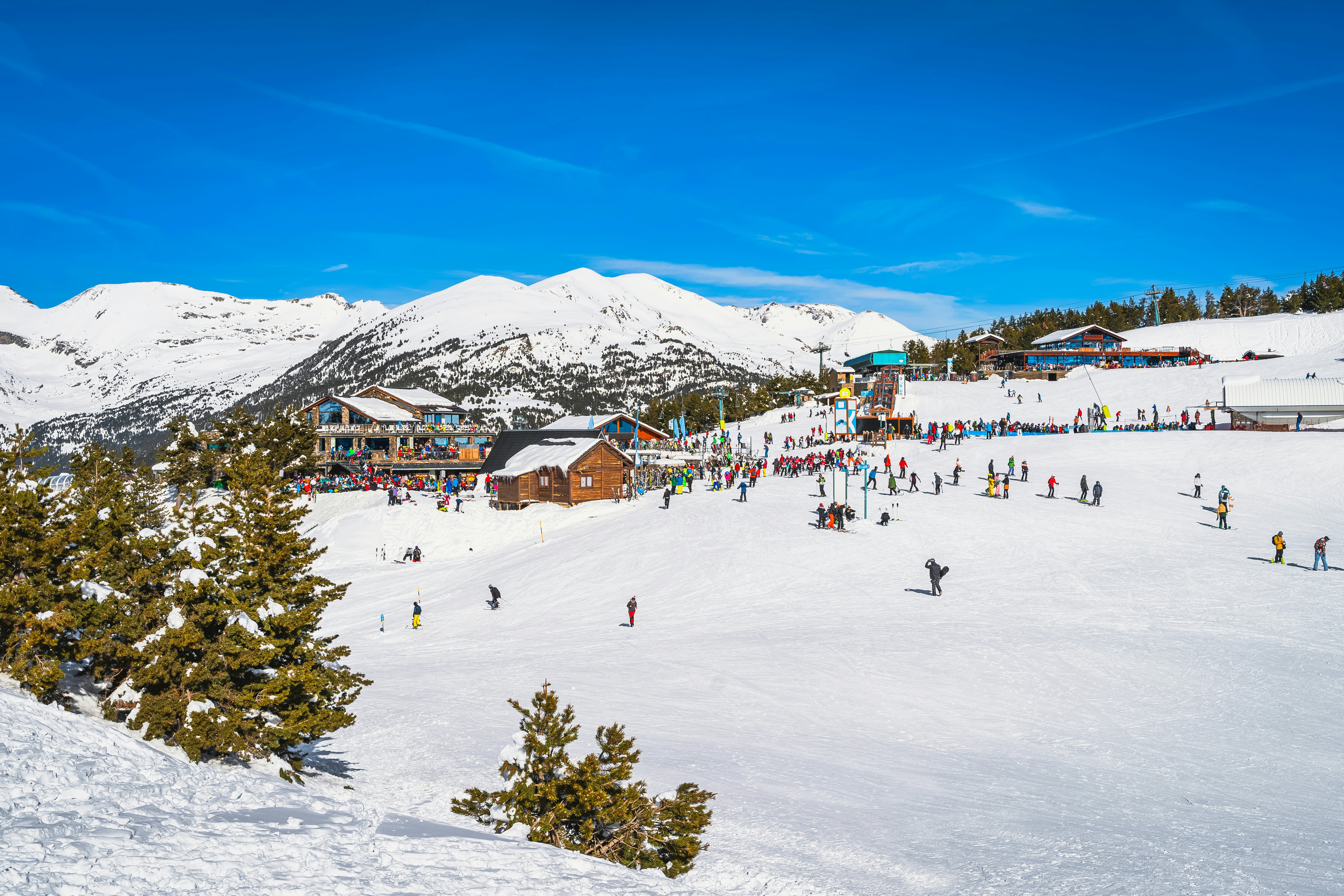 A ski area with snow-capped mountains and people skiing