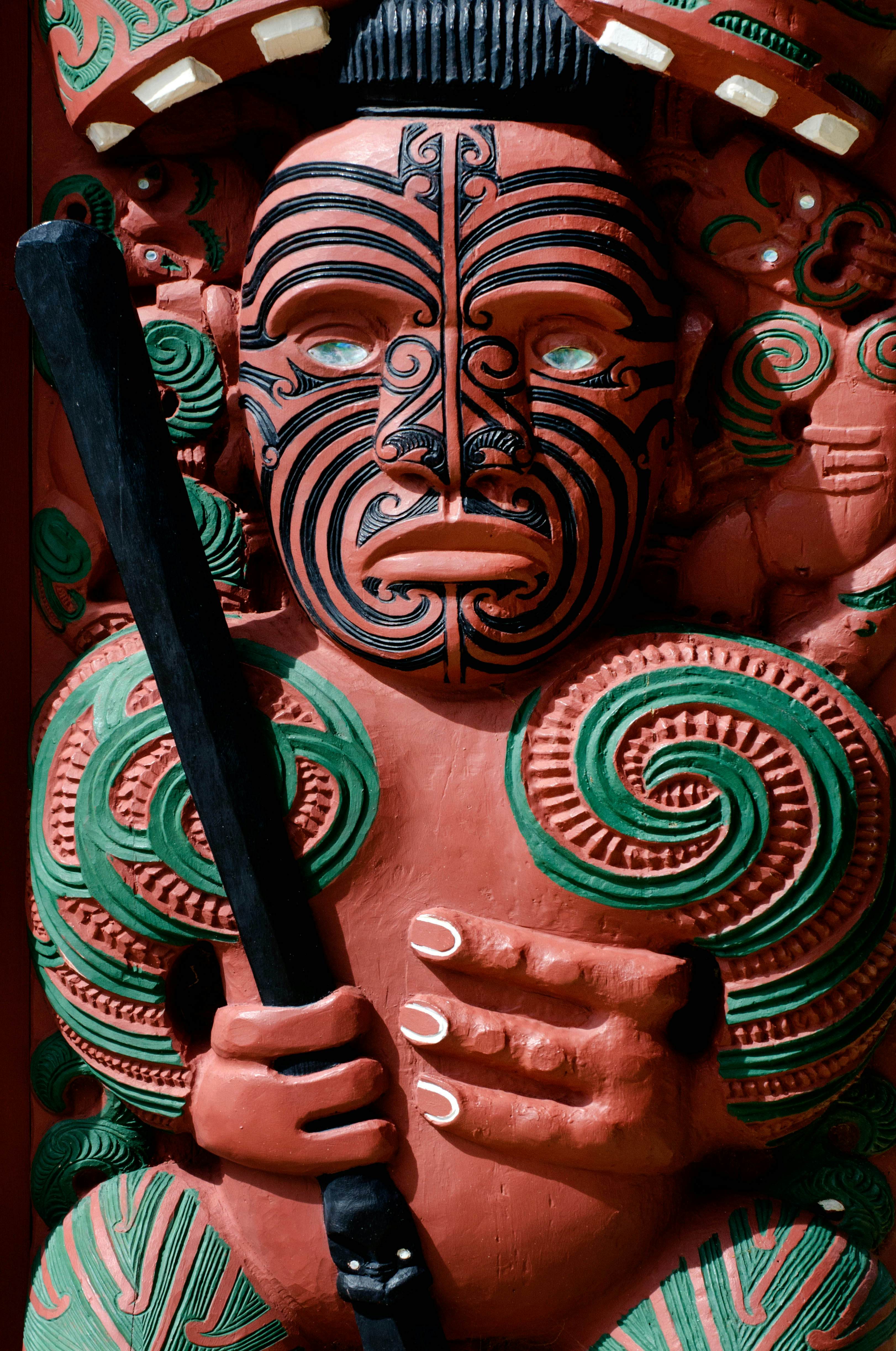 A carved statue of a human figure painted red and green.