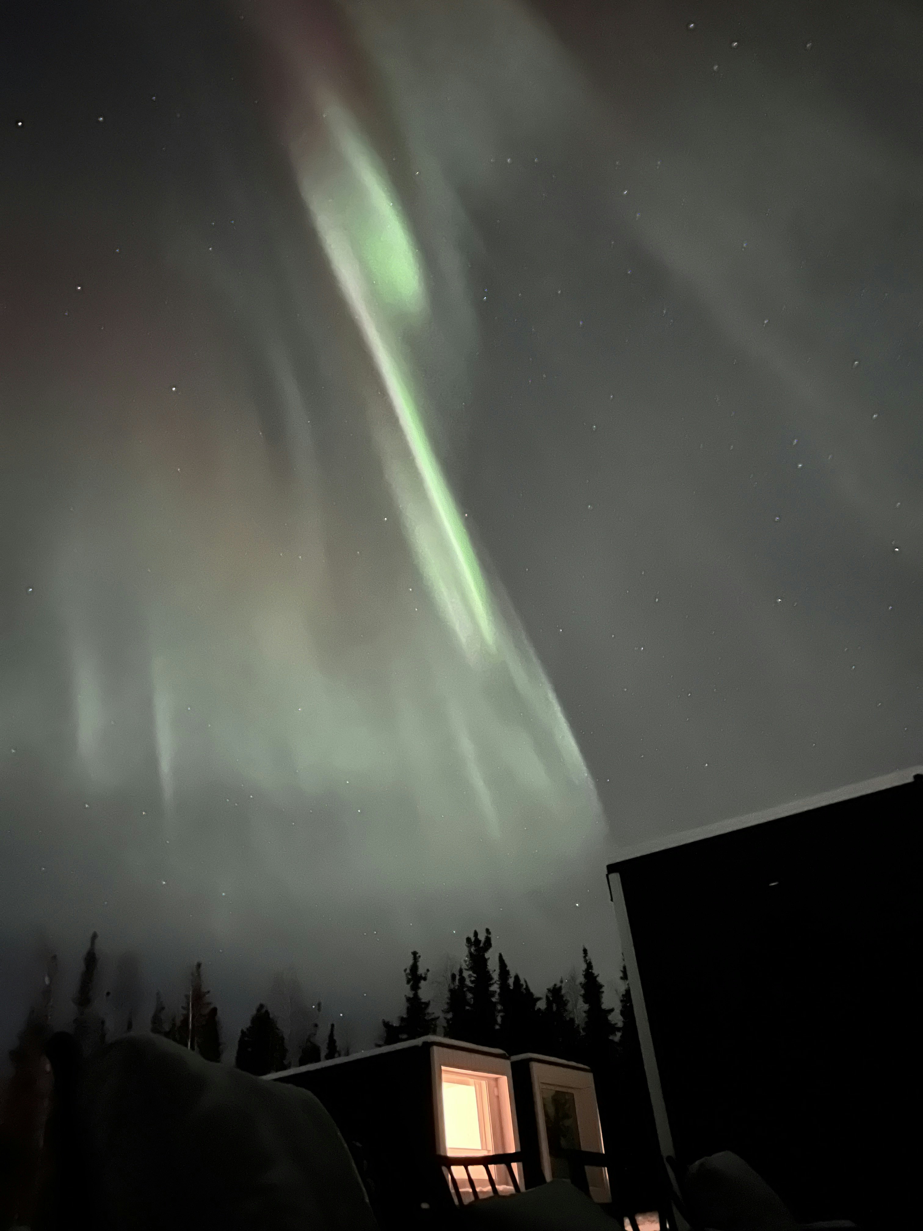 Wisps of aurora borealis light up a starry sky in Alaska.
