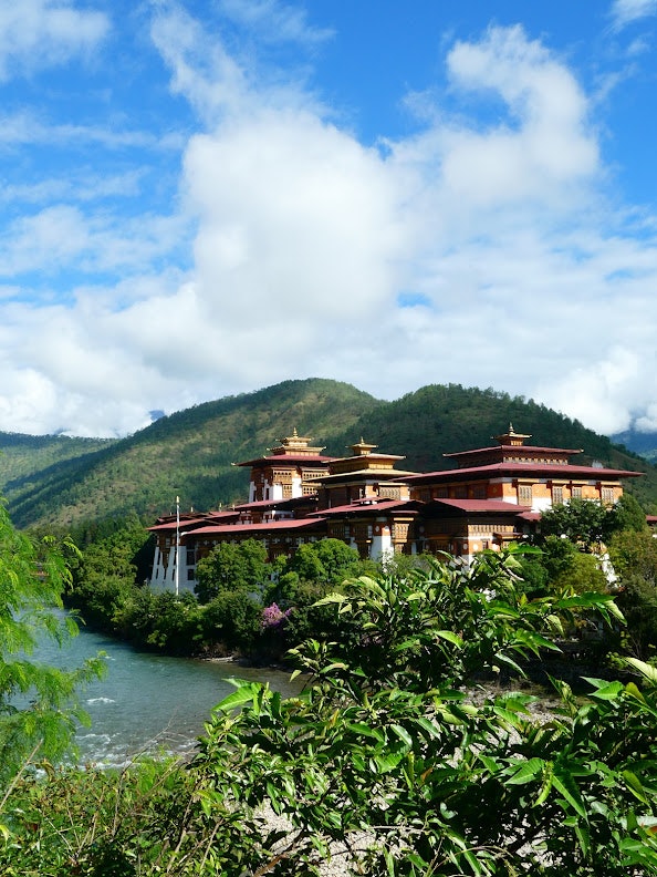 A large temple surrounded by trees and mountains.