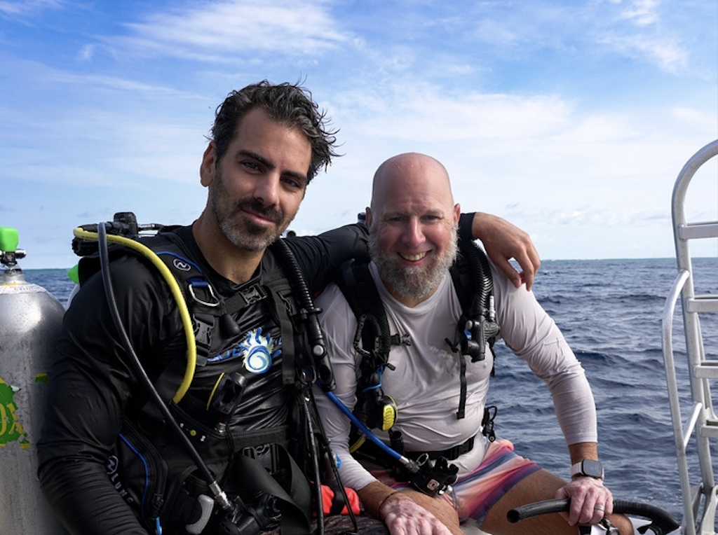 Two men on a boat in the ocean. 