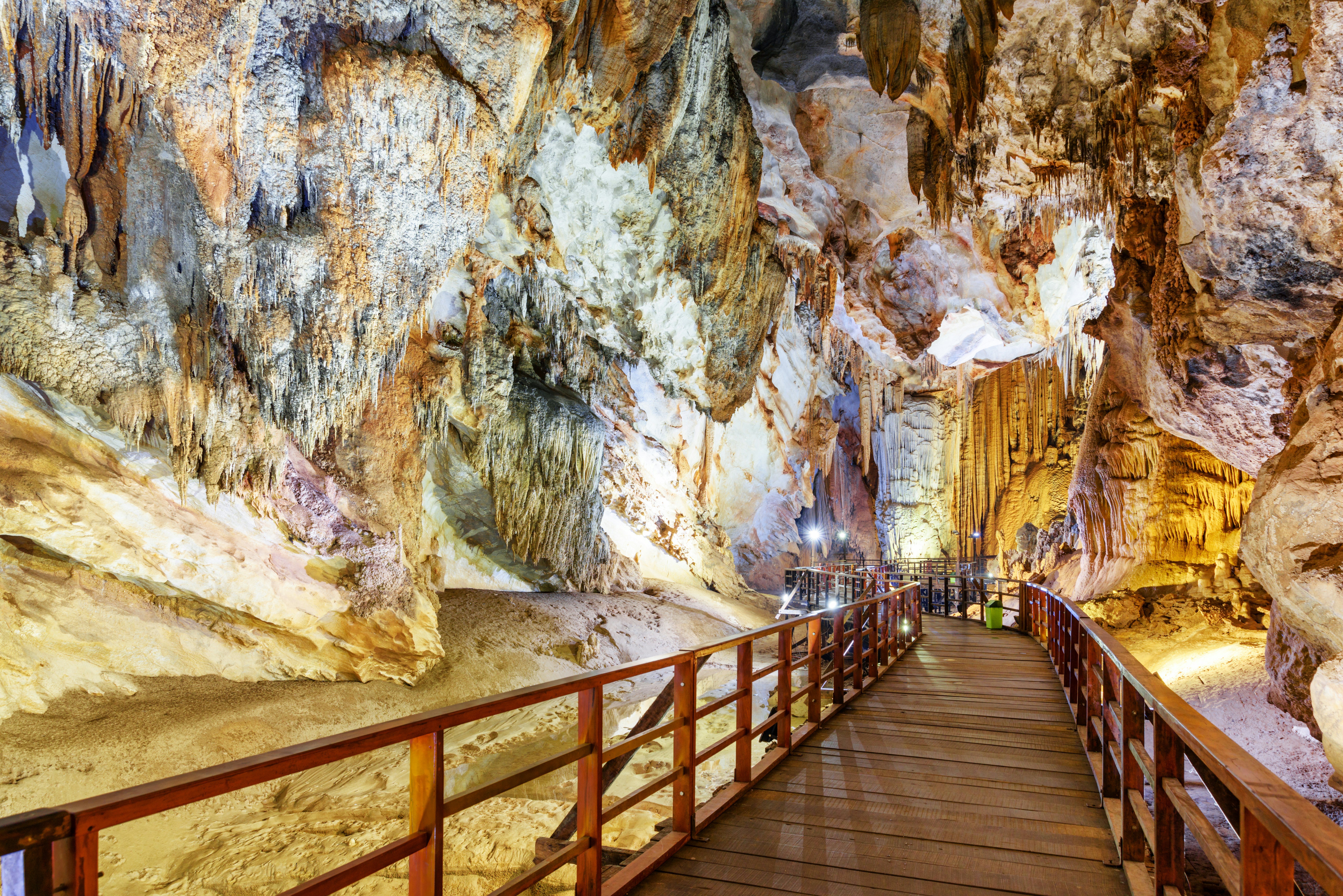 A wooden walkway leads through a cave system with many karst peaks.