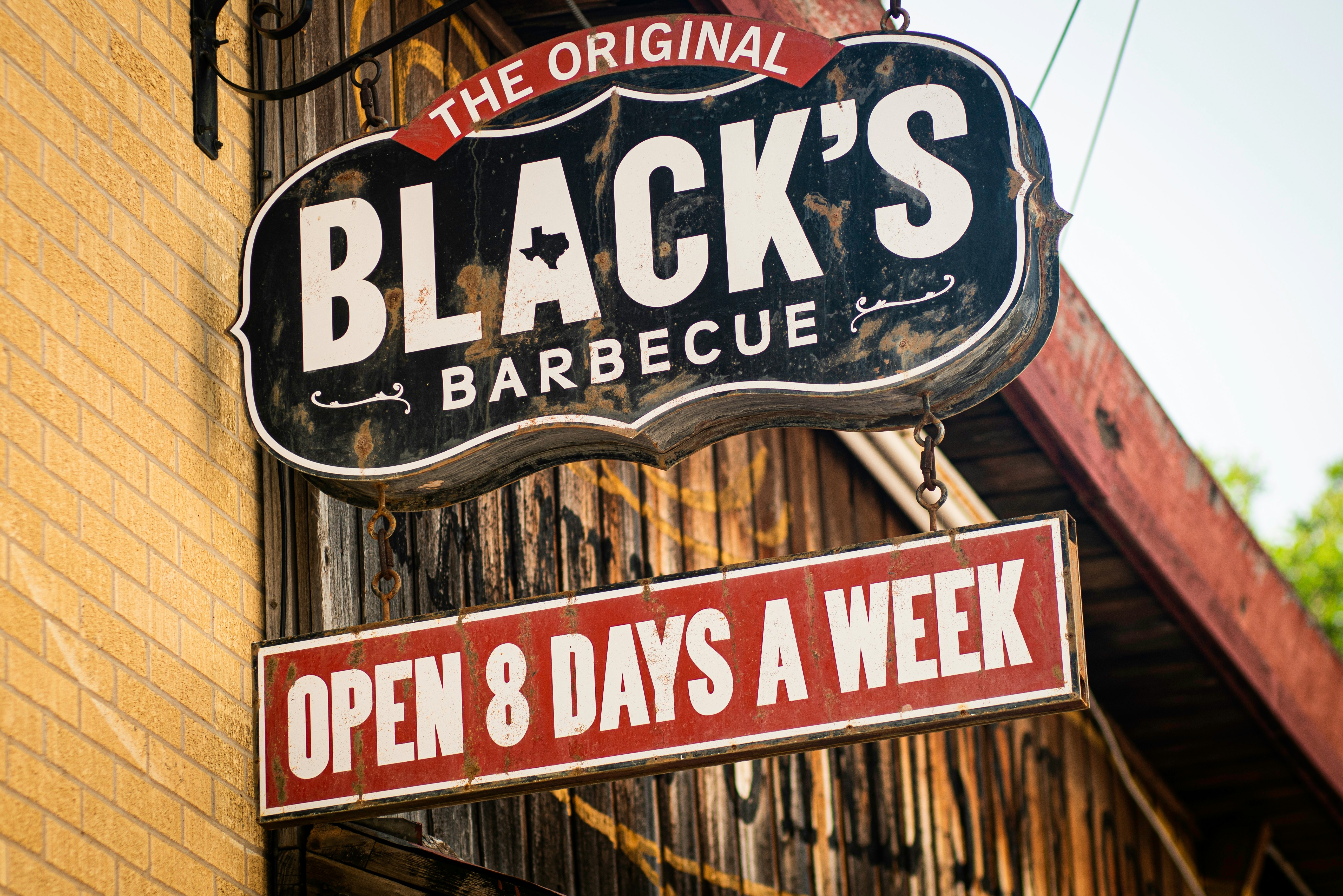 A sign for the original Black's Barbecue open 8 days a week