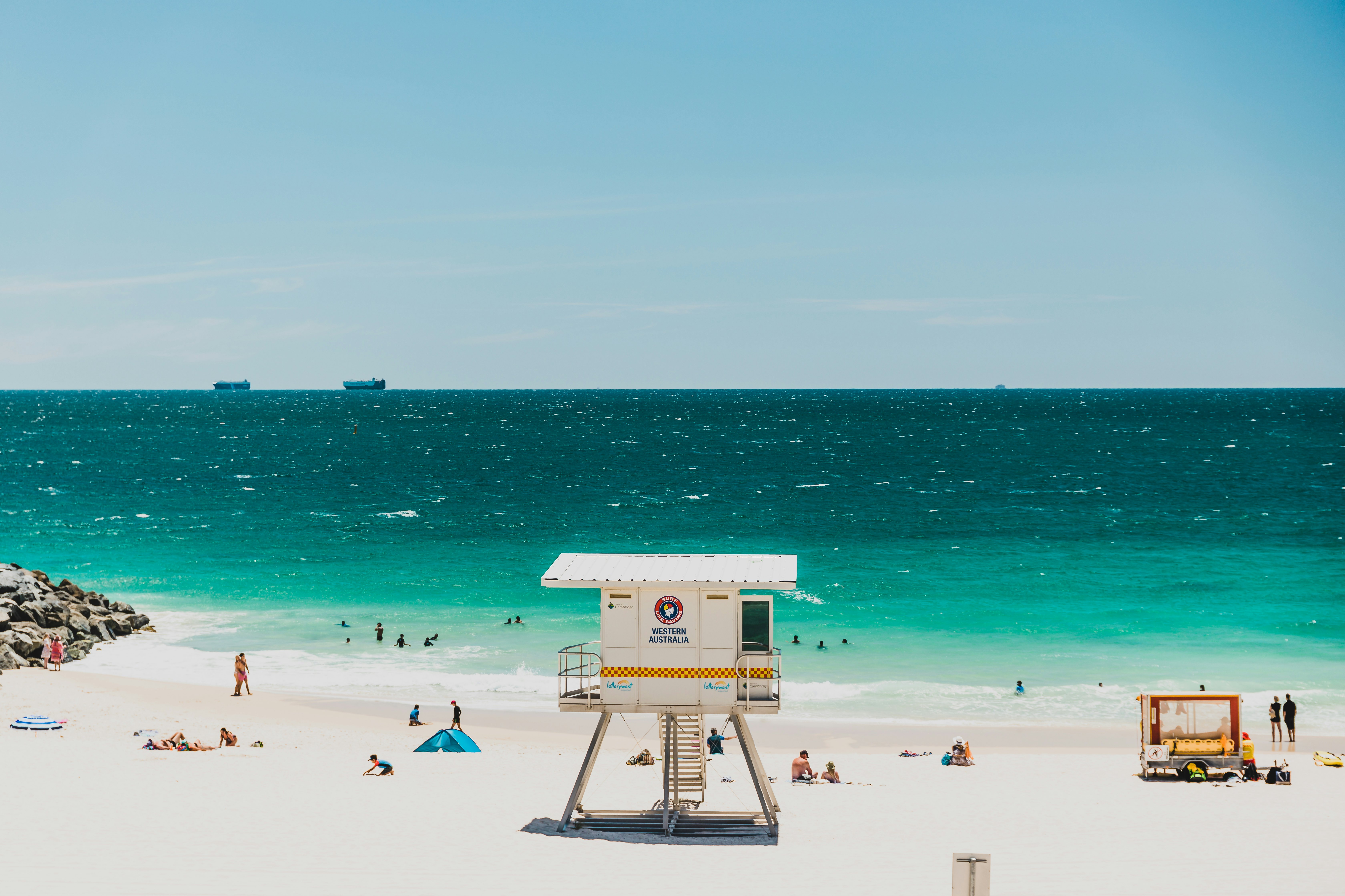 A lifeguard hut on a sandy beach facing the turquoise ocean.