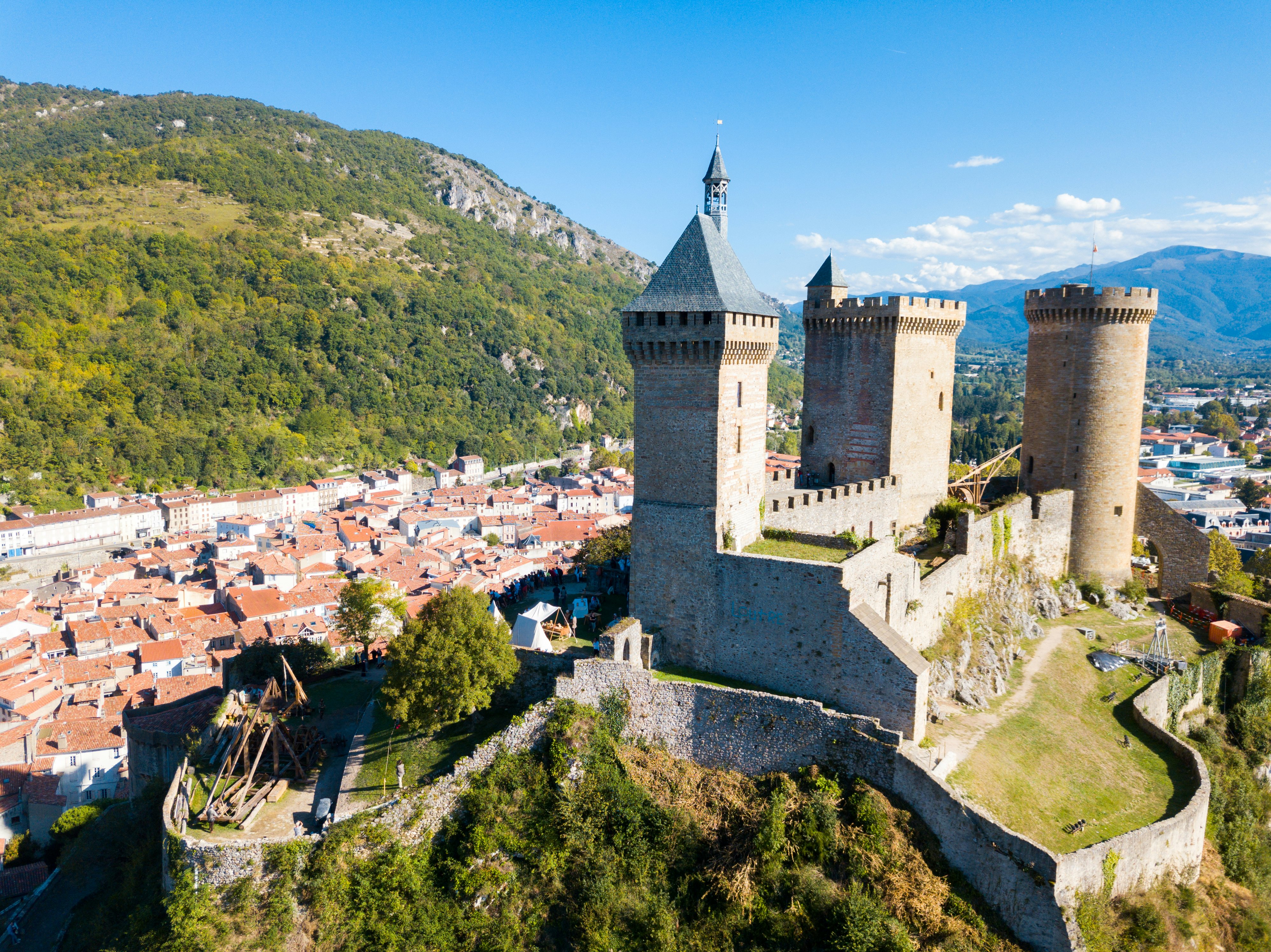 Picturesque autumn landscape with imposing medieval fortress Chateau de Foix on hill, France