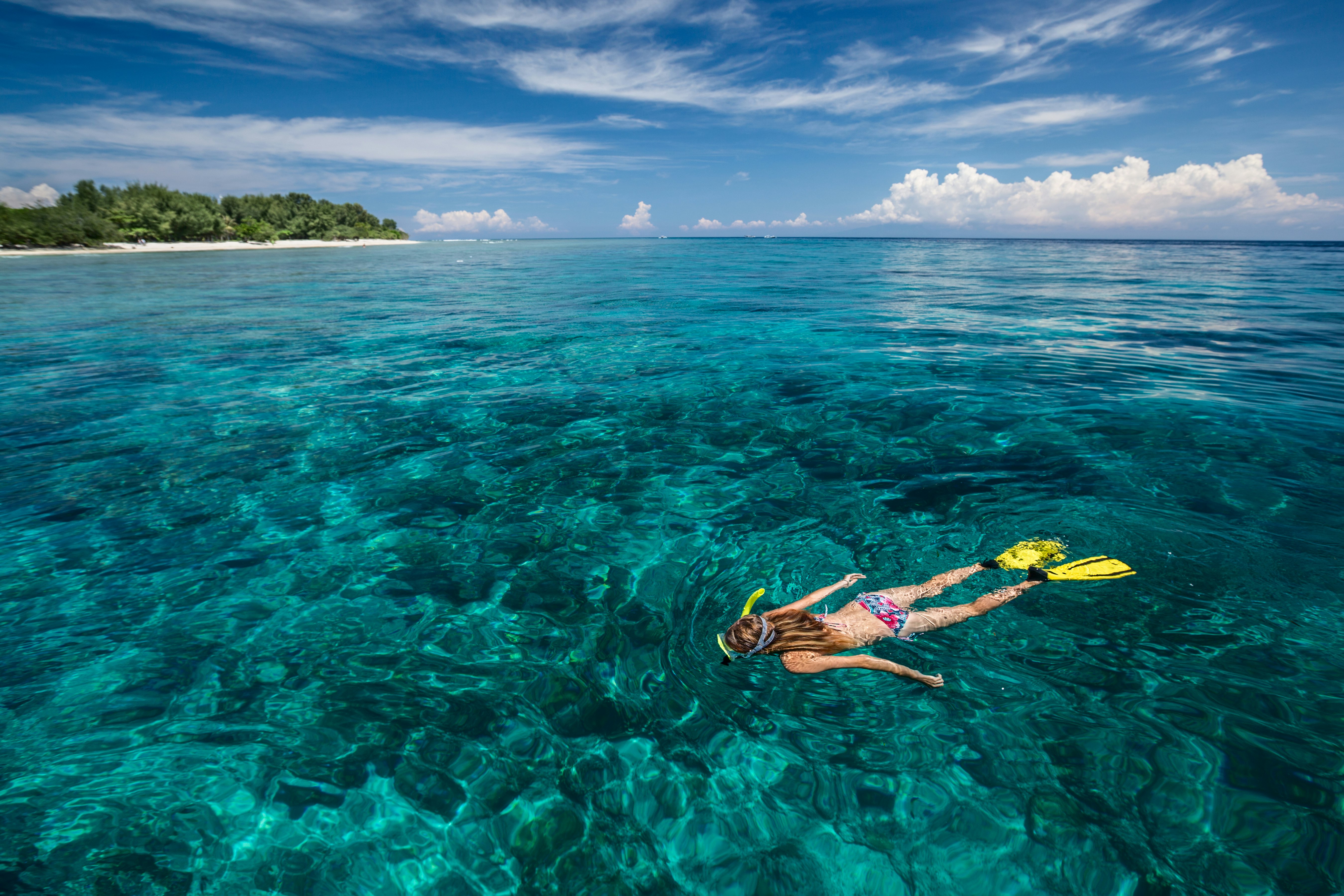 A person snorkeling in turquoise water near Gili Trawangan