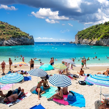 Corfu, Greece -August 17, 2015: Beautiful beach in Paleokastritsa on Corfu, tourists enjoying a nice summer day at the beach. Kerkyra (Corfu), Greece License Type: media Download Time: 2023-01-11T03:27:11.000Z User: aomi.ito_lonelyplanet Is Editorial: Yes purchase_order: