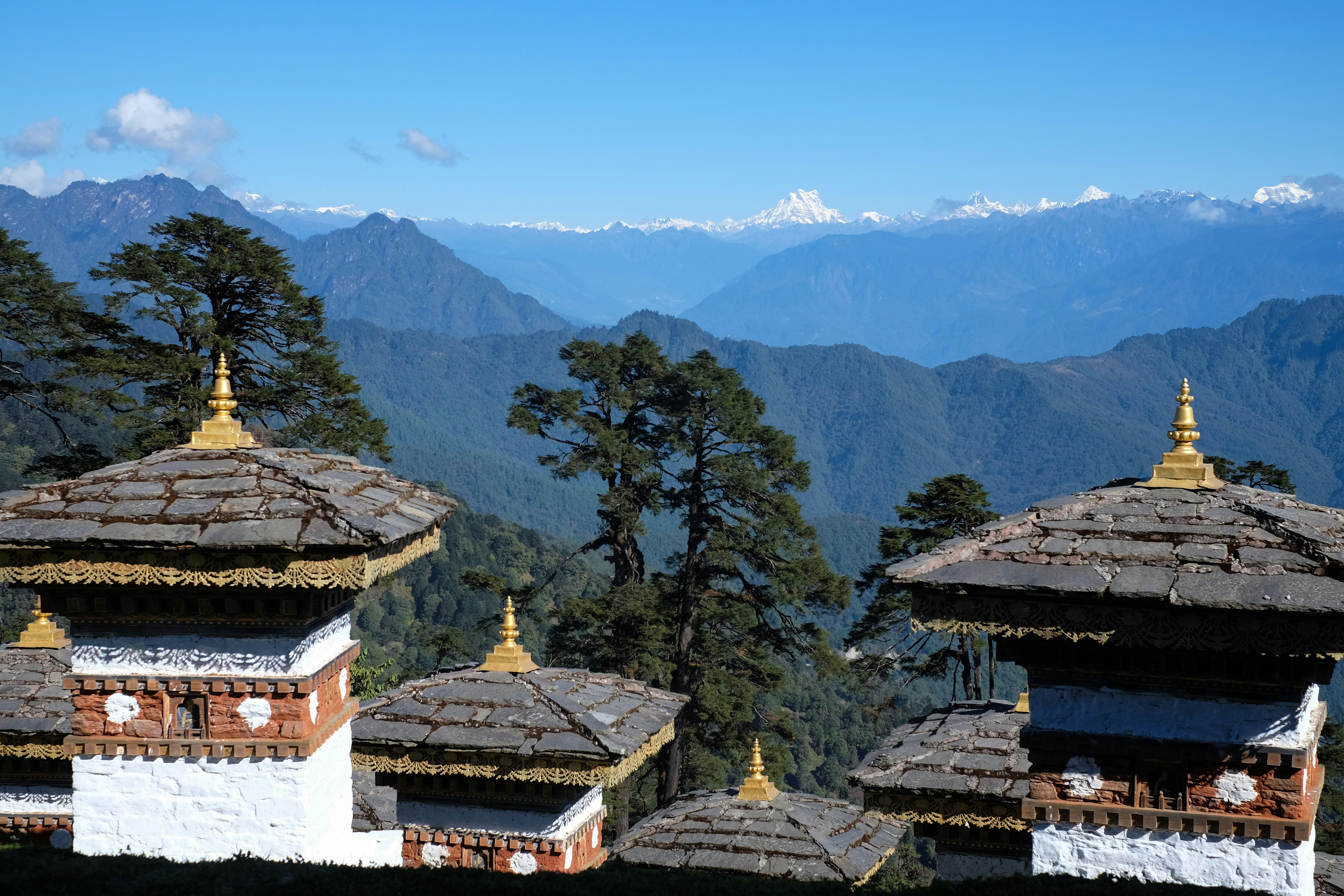 A temple in front of a view of the snowy Himalayas.